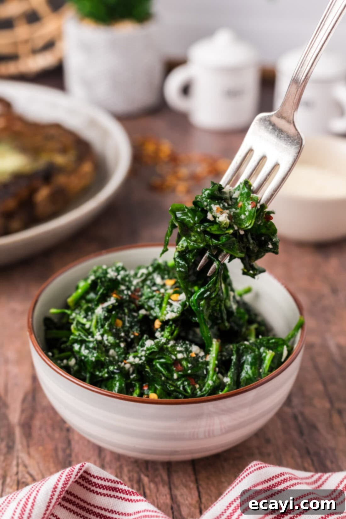 Forkful of Air Fryer Spinach being lifted out of a bowl of Air Fryer Spinach