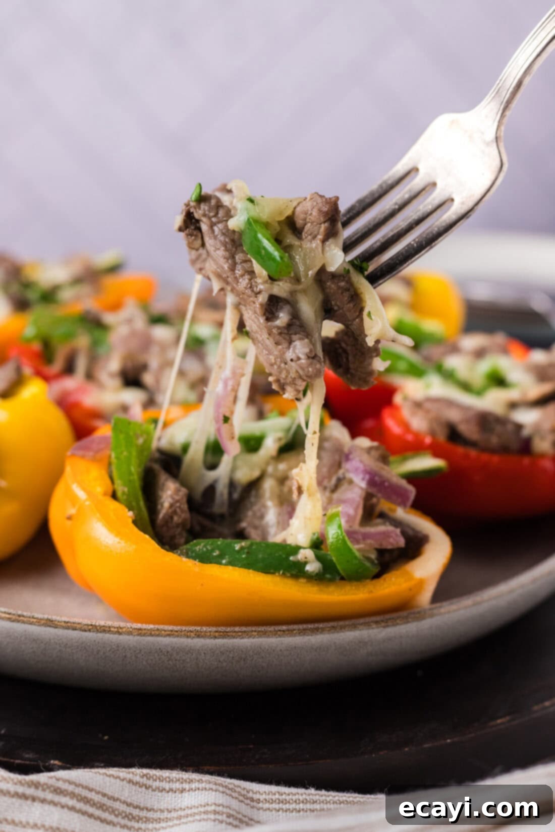Loaded Philly Cheesesteak Peppers 3 Fork pulling up pieces of Philly Cheesesteak Stuffed Peppers