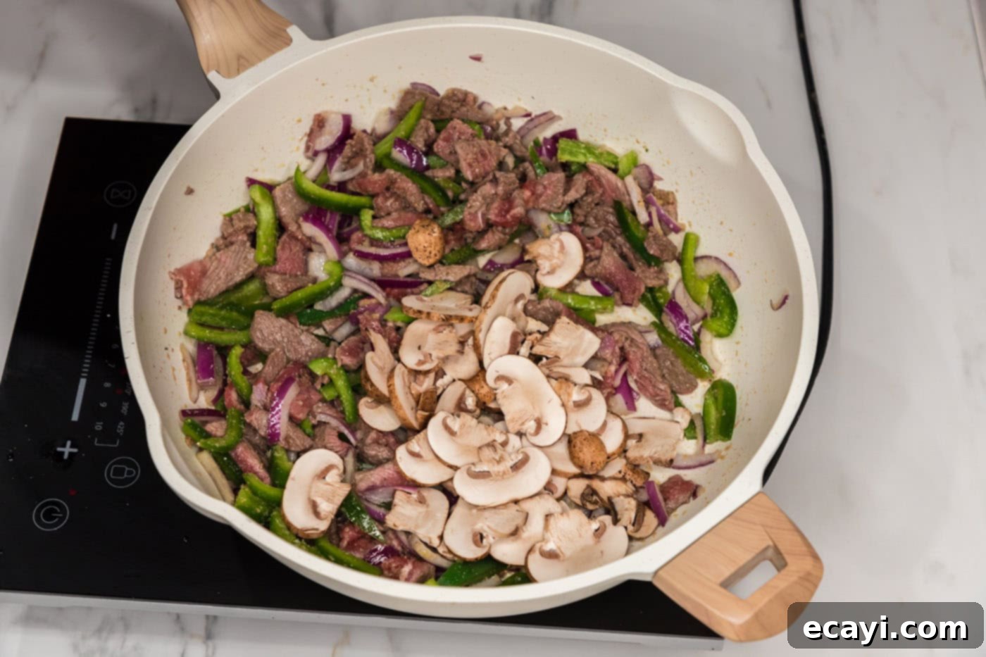 Loaded Philly Cheesesteak Peppers 5 red onion, mushrooms, green bell peppers, and sliced steak in a skillet
