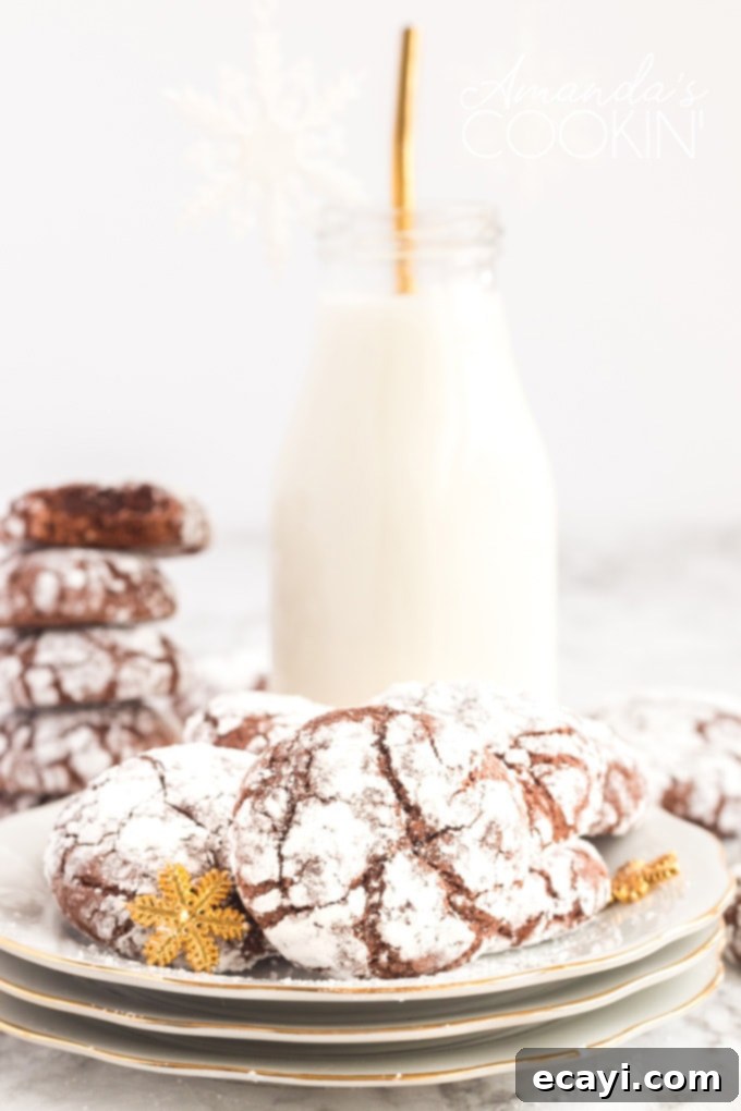 Chocolate Snow Cookies - perfect for holiday get togethers or cookie exchanges! chocolate crinkle cookies on plate with bottle of milk