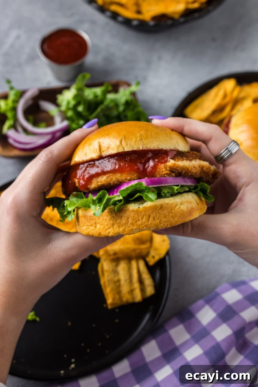 Zesty Shrimp Burger 3 Hands holding a perfectly cooked, golden-brown shrimp burger with a crispy coating
