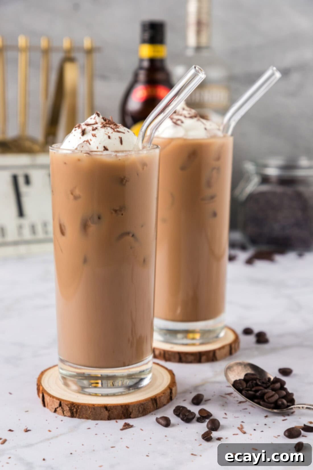 Cold Buzz Coffee 2 Two Spiked Iced Coffees on wooden coasters, garnished with whipped cream and chocolate shavings.