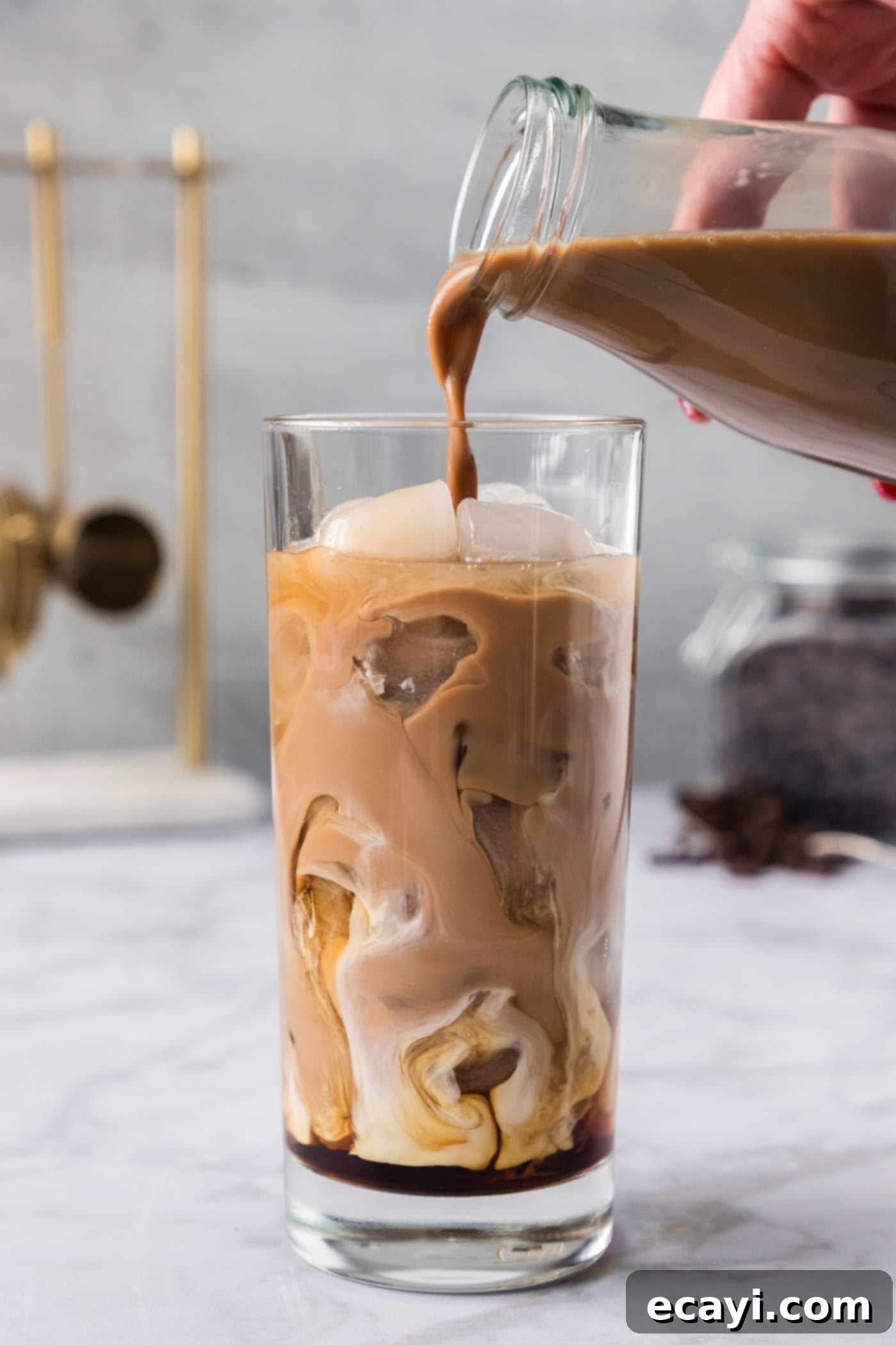 Cold Buzz Coffee 6 Pouring iced coffee into a glass of ice with Kahlua and vanilla vodka, creating layers