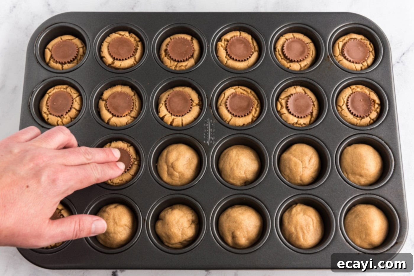 Reese's Peanut Butter Cup Stuffed Cookies 11 pressing Reeses mini peanut butter cups into peanut butter cookies in a mini muffin pan