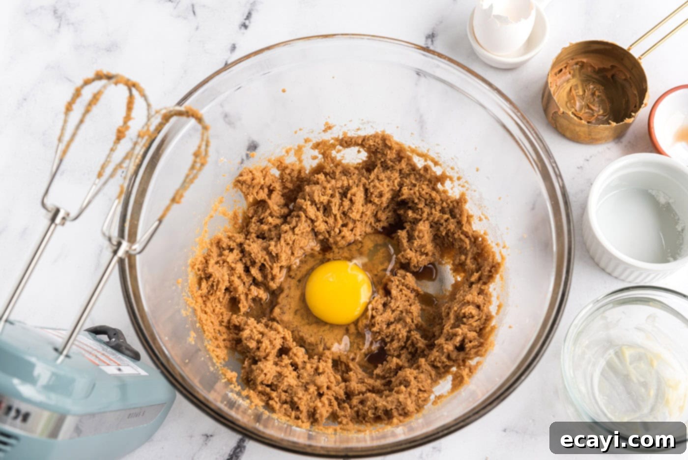 Reese's Peanut Butter Cup Stuffed Cookies 6 adding egg to peanut butter cookie dough in a mixer bowl