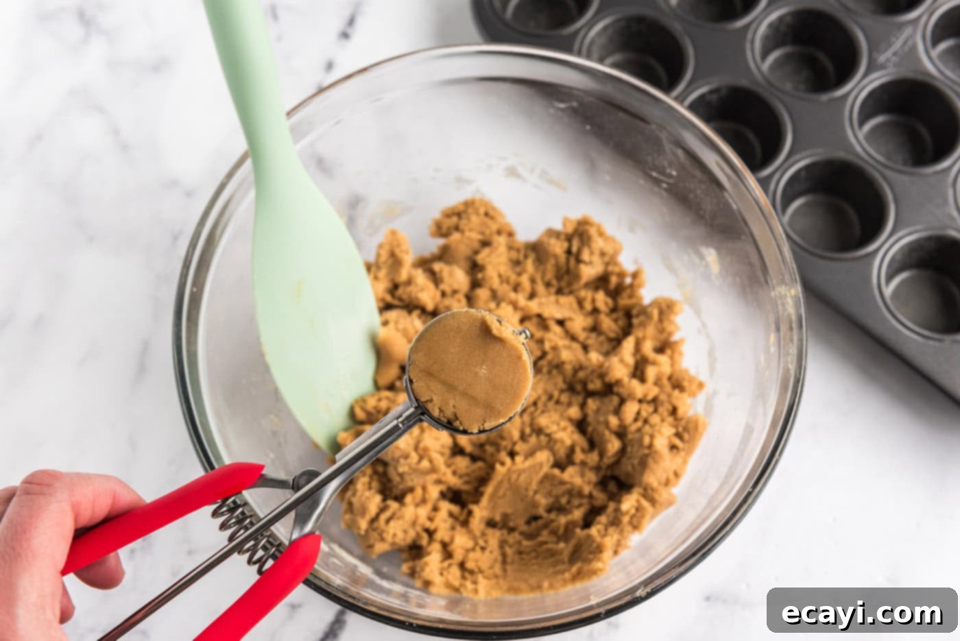 Reese's Peanut Butter Cup Stuffed Cookies 9 scooping peanut butter cookie dough from bowl with a cookie scoop