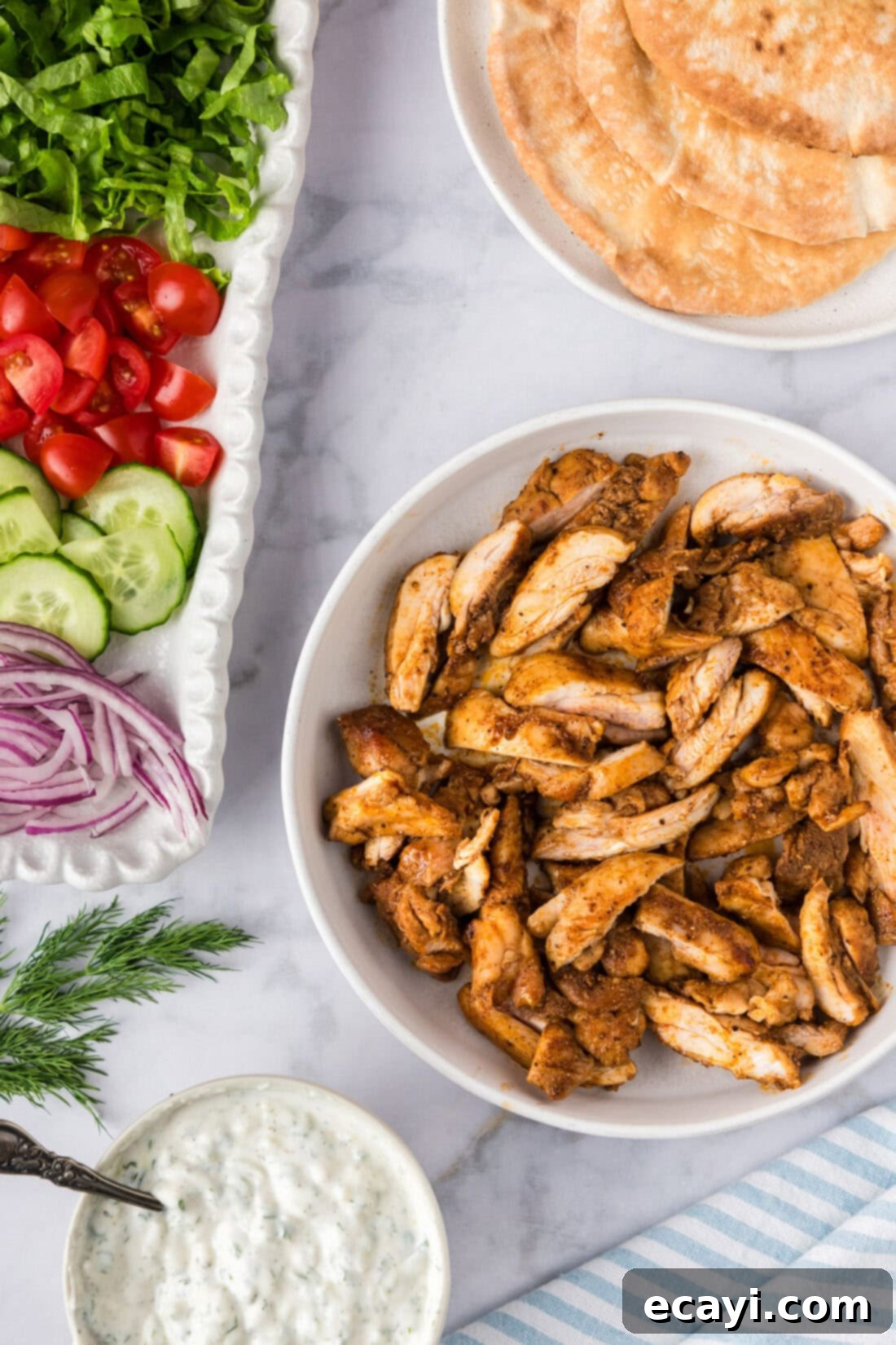 Authentic Chicken Shawarma 2 A vibrant bowl of homemade chicken shawarma, artfully arranged with creamy tzatziki, smooth hummus, and an assortment of fresh, crisp vegetables on the side, inviting you to create your perfect wrap.