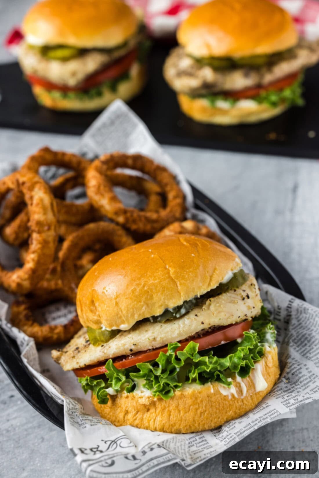 Crispy Chicken Sandwich 2 Juicy grilled chicken sandwich in a basket with crispy onion rings, ready to be enjoyed.