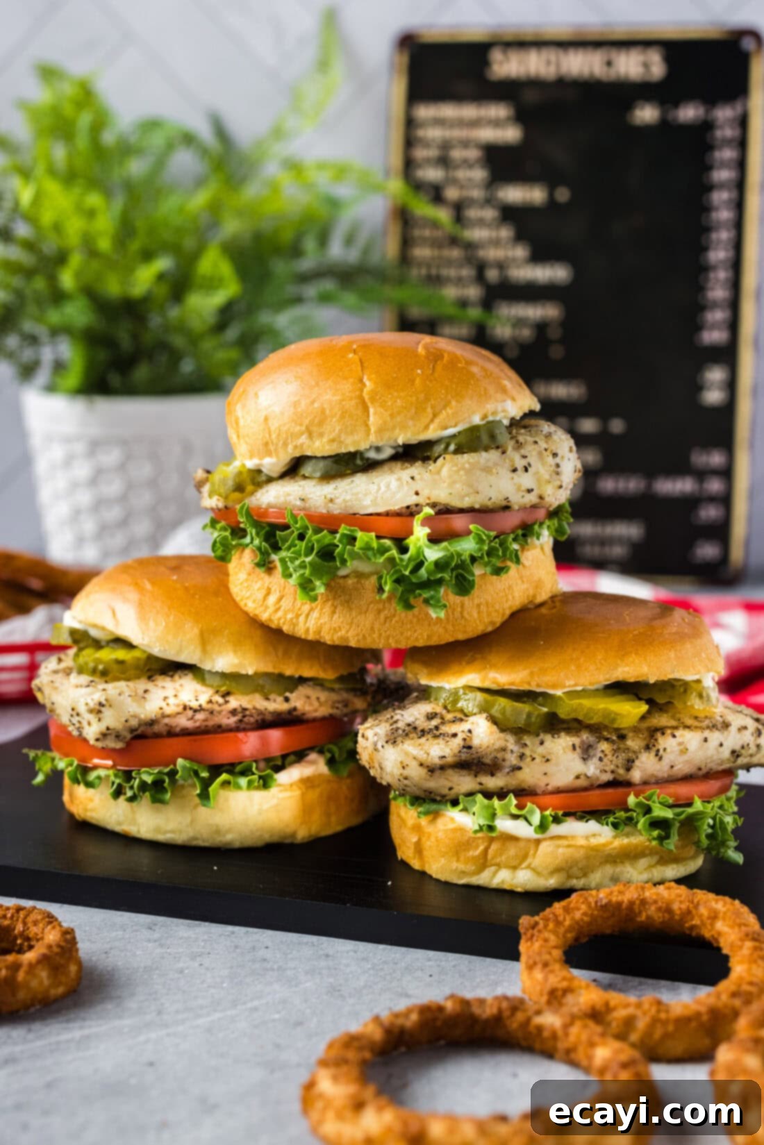 Crispy Chicken Sandwich 3 Three perfectly stacked grilled chicken sandwiches, showcasing their delicious layers of chicken, bun, and fresh ingredients.