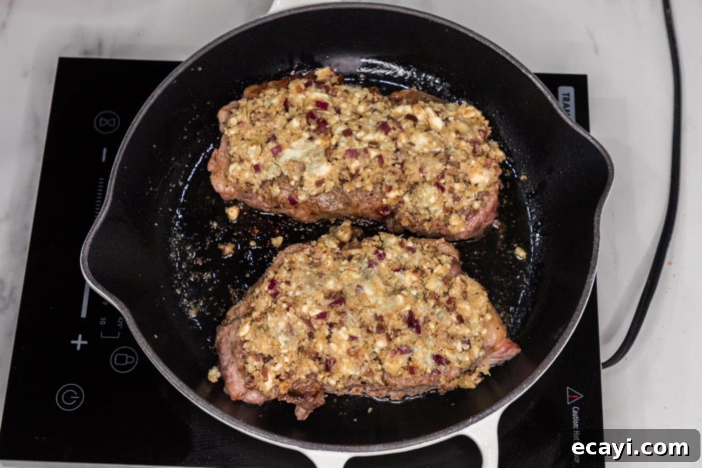 Signature Blue Cheese Crusted Steak 11 Blue cheese mixture generously spread over the top of a seared steak still in the skillet.