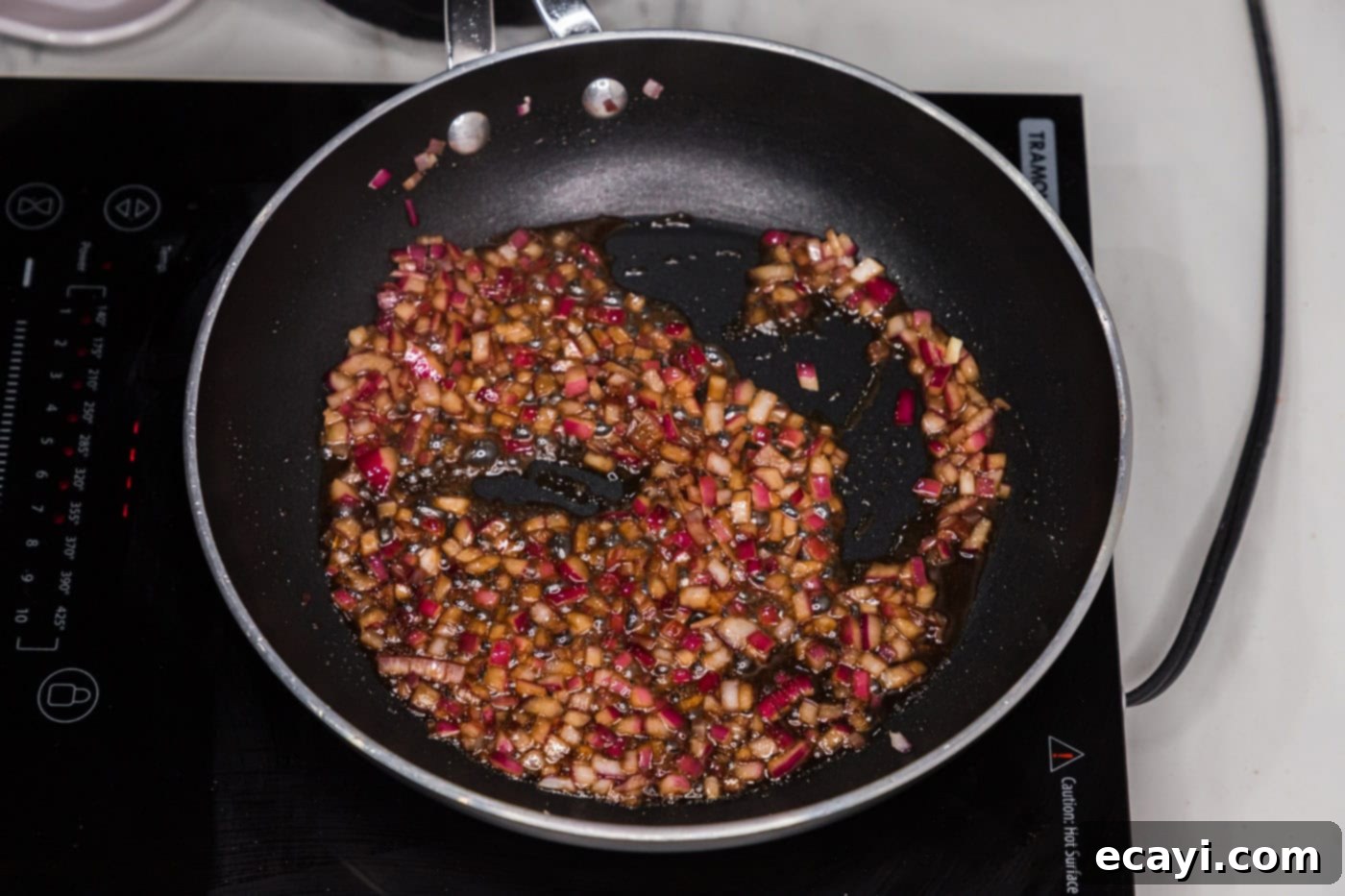 Signature Blue Cheese Crusted Steak 6 Diced red onion sauteeing in olive oil in a skillet, with liquid smoke and Worcestershire sauce added and simmering.