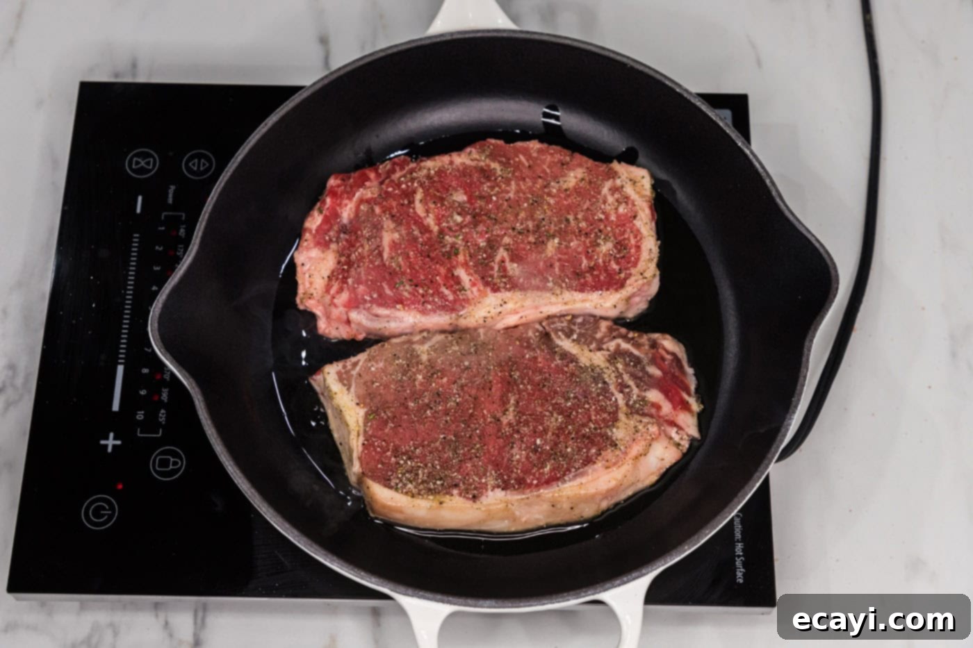 Signature Blue Cheese Crusted Steak 9 A New York strip steak sizzling and searing in a hot skillet, developing a dark brown crust.