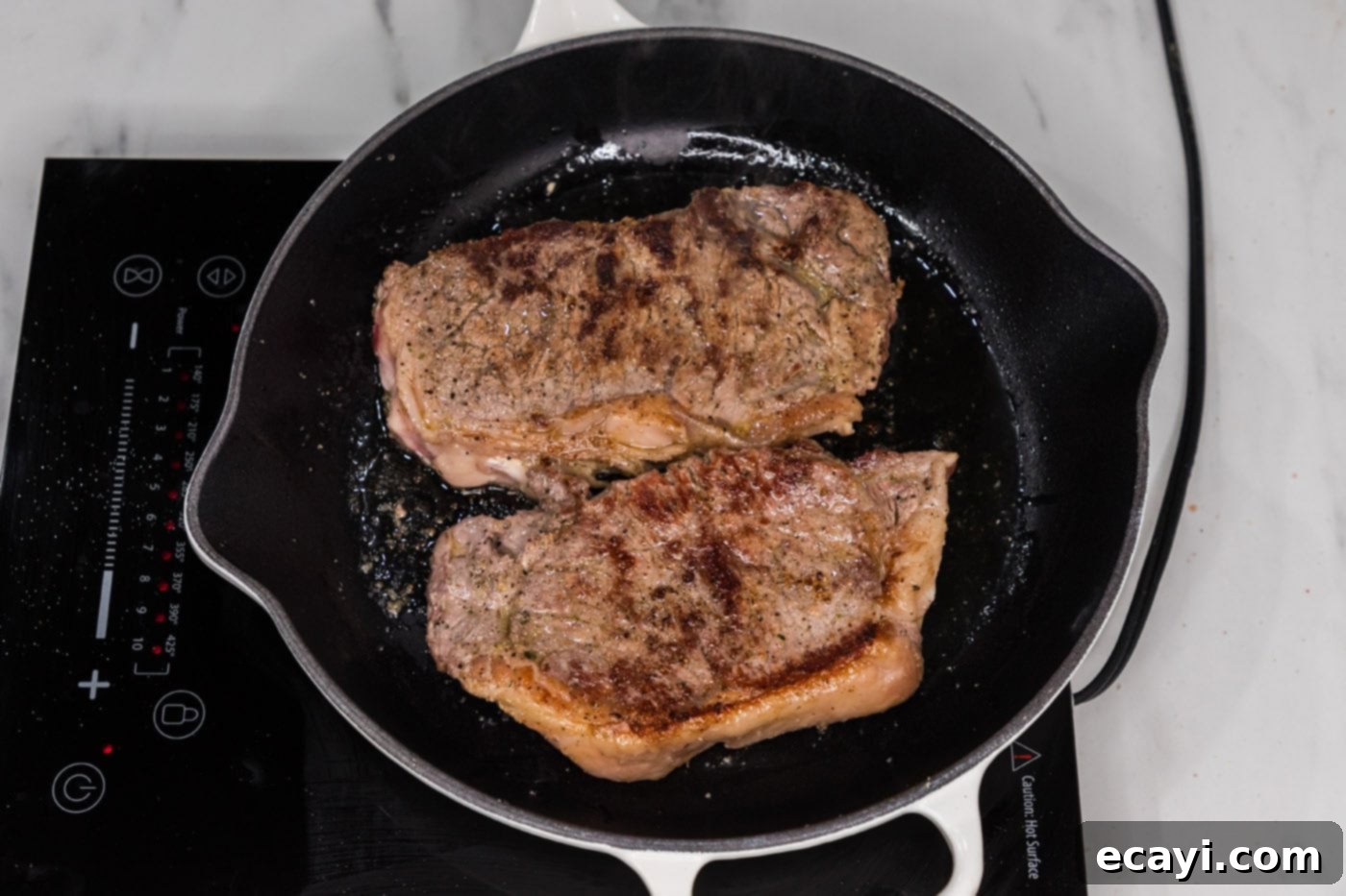 Signature Blue Cheese Crusted Steak 10 The second side of a New York strip steak perfectly browned and seared in a skillet.