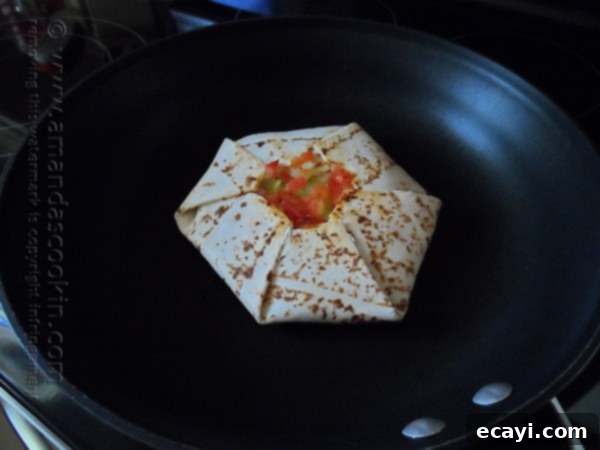 The Ultimate At-Home Crunchwrap 9 A homemade Crunchwrap Supreme cooking in a skillet, with one side already golden brown and crispy.