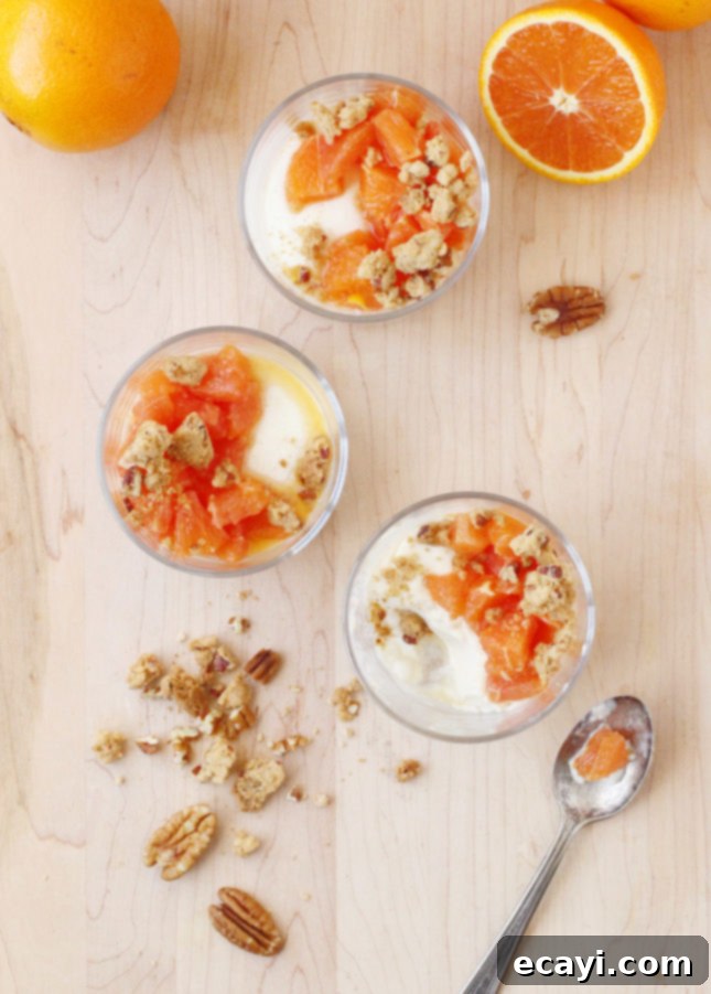 Maple Orange Velvet with Toasted Pecan Crumbles 5 A single serving of Orange Maple Panna Cotta in a glass, beautifully adorned with diced Cara Cara oranges and a generous topping of pecan-maple crumble, inviting a taste
