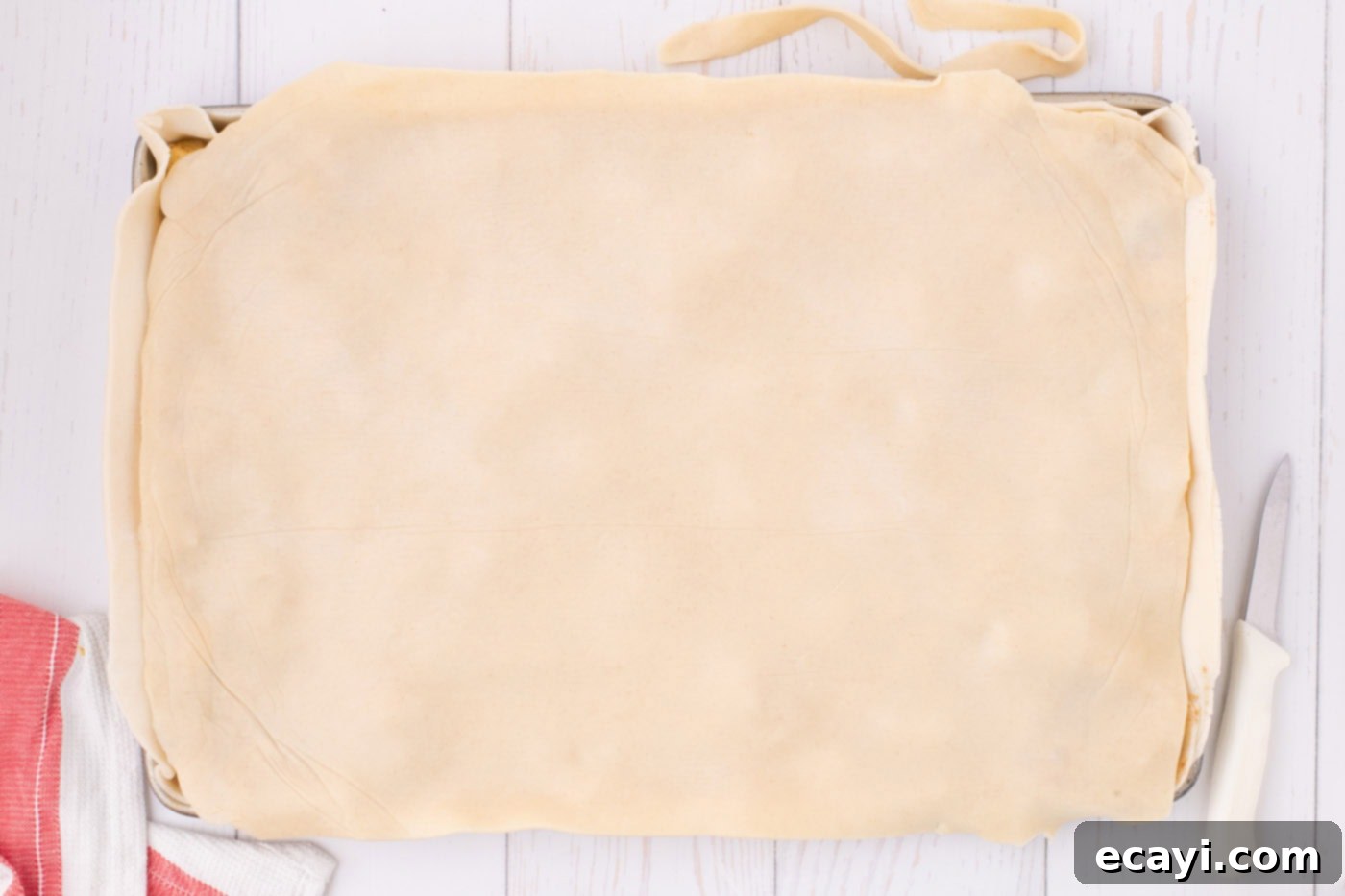 Sheet Pan Apple Pie 10 pie crust over top chopped apples in a jelly roll pan