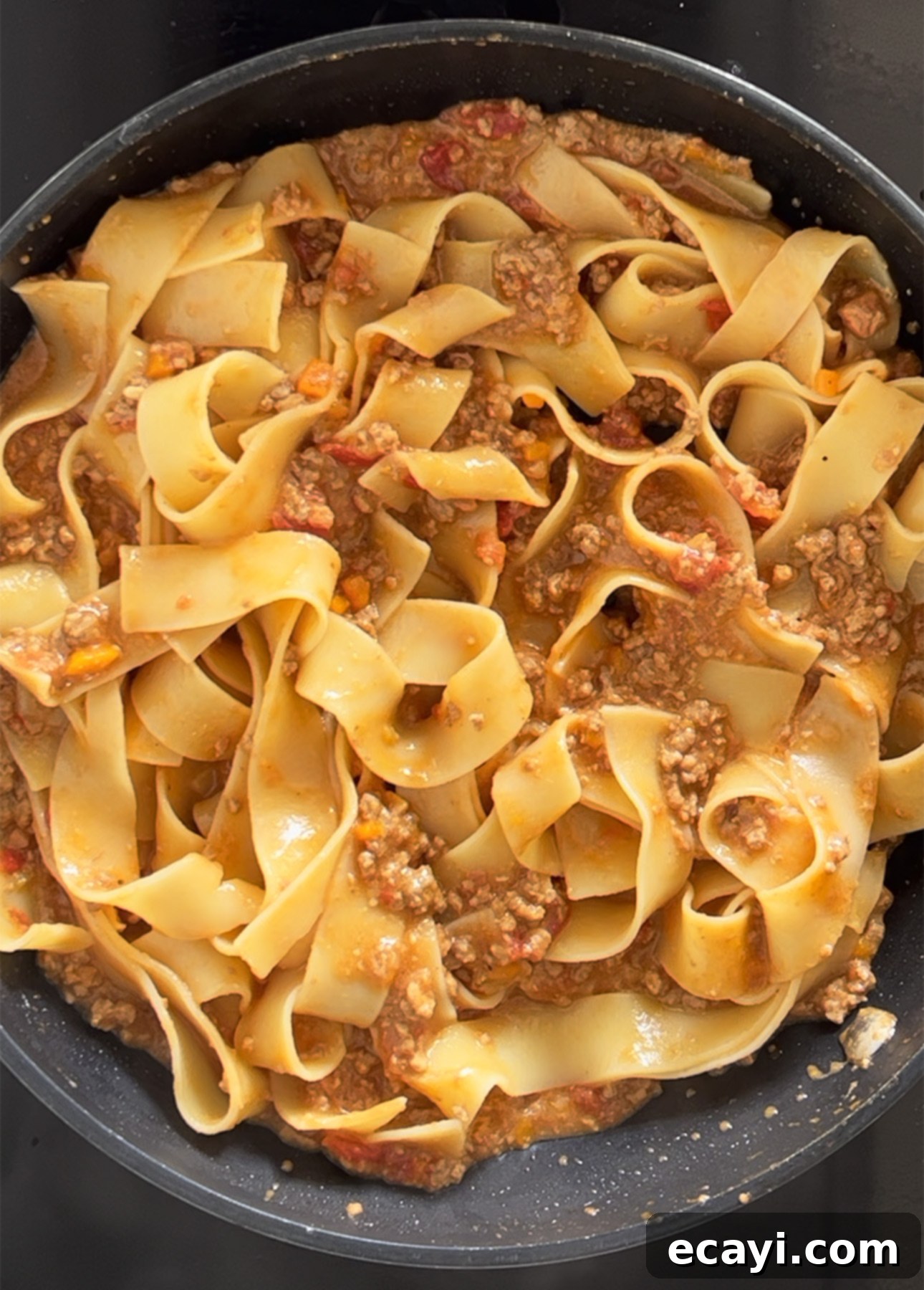 Master Authentic Bolognese Sauce 14 Pappardelle pasta with rich Bolognese sauce being tossed in a skillet, ready to serve