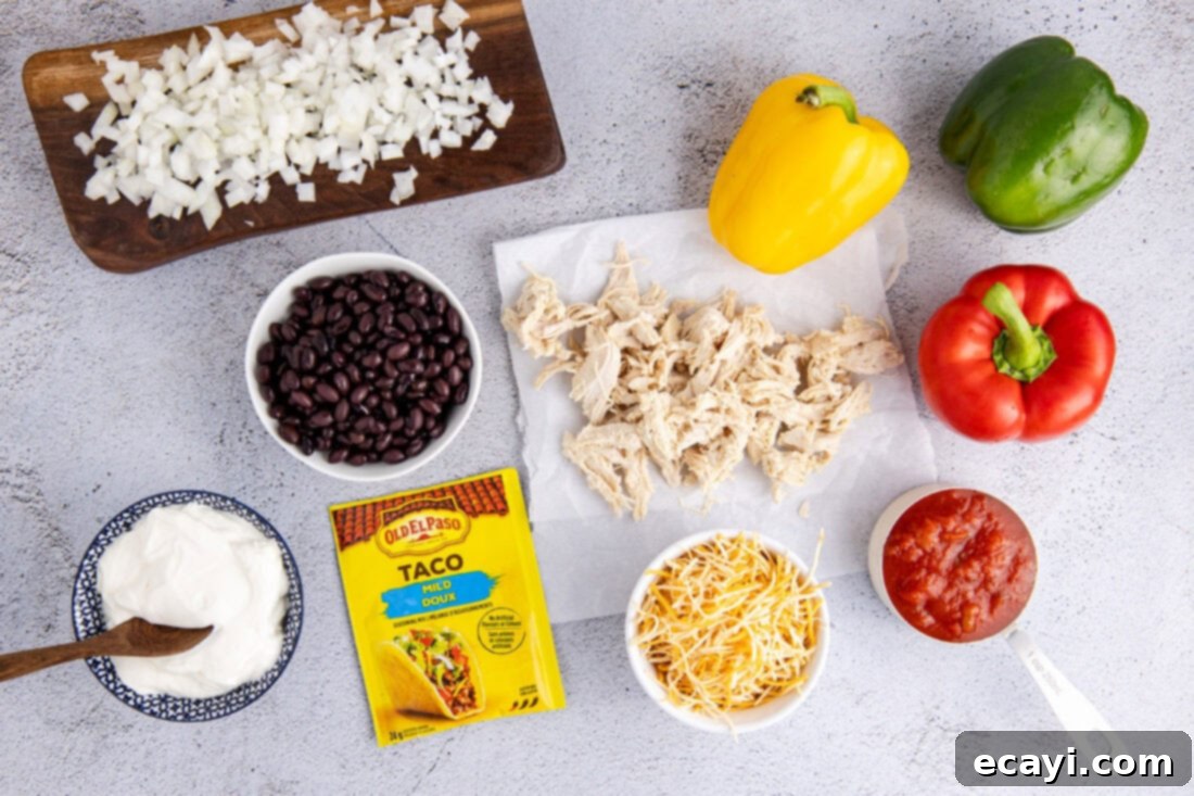 Cheesy Chicken Taco Casserole 4 Various ingredients laid out for Chicken Taco Casserole, including chicken, cheese, salsa, sour cream, and fresh vegetables.