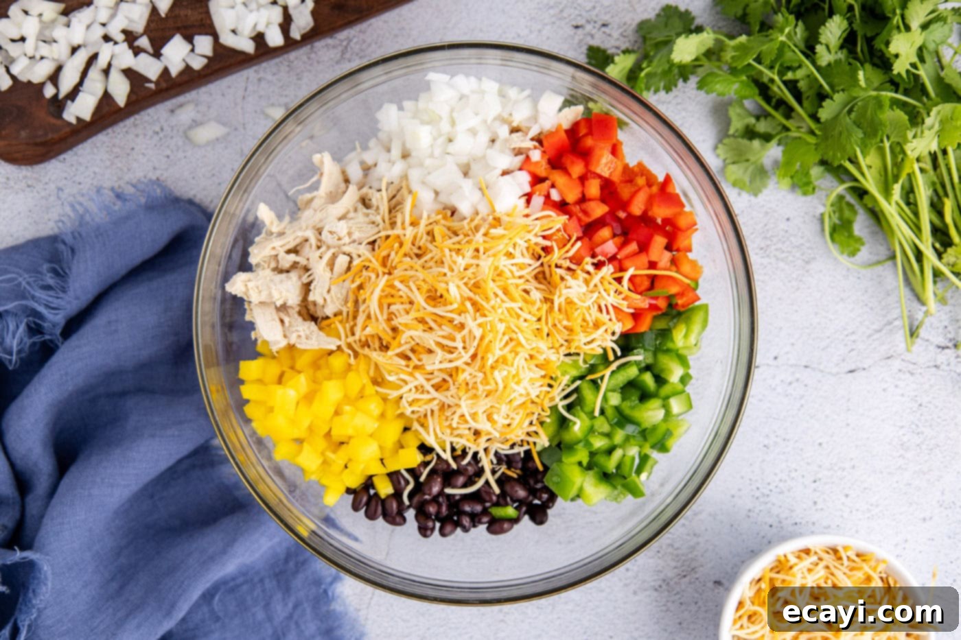 Cheesy Chicken Taco Casserole 6 shredded cheese, diced bell peppers, onion, cooked chicken, and black beans in a large bowl, ready for mixing.
