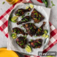 Caribbean Jerk Chicken 11 Jerk Chicken on a parchment lined serving tray with limes on the side