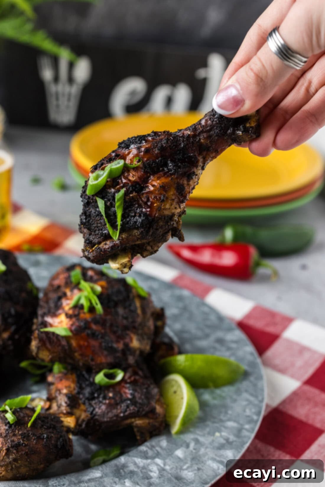 Caribbean Jerk Chicken 3 Hand holding up a piece of Jerk Chicken