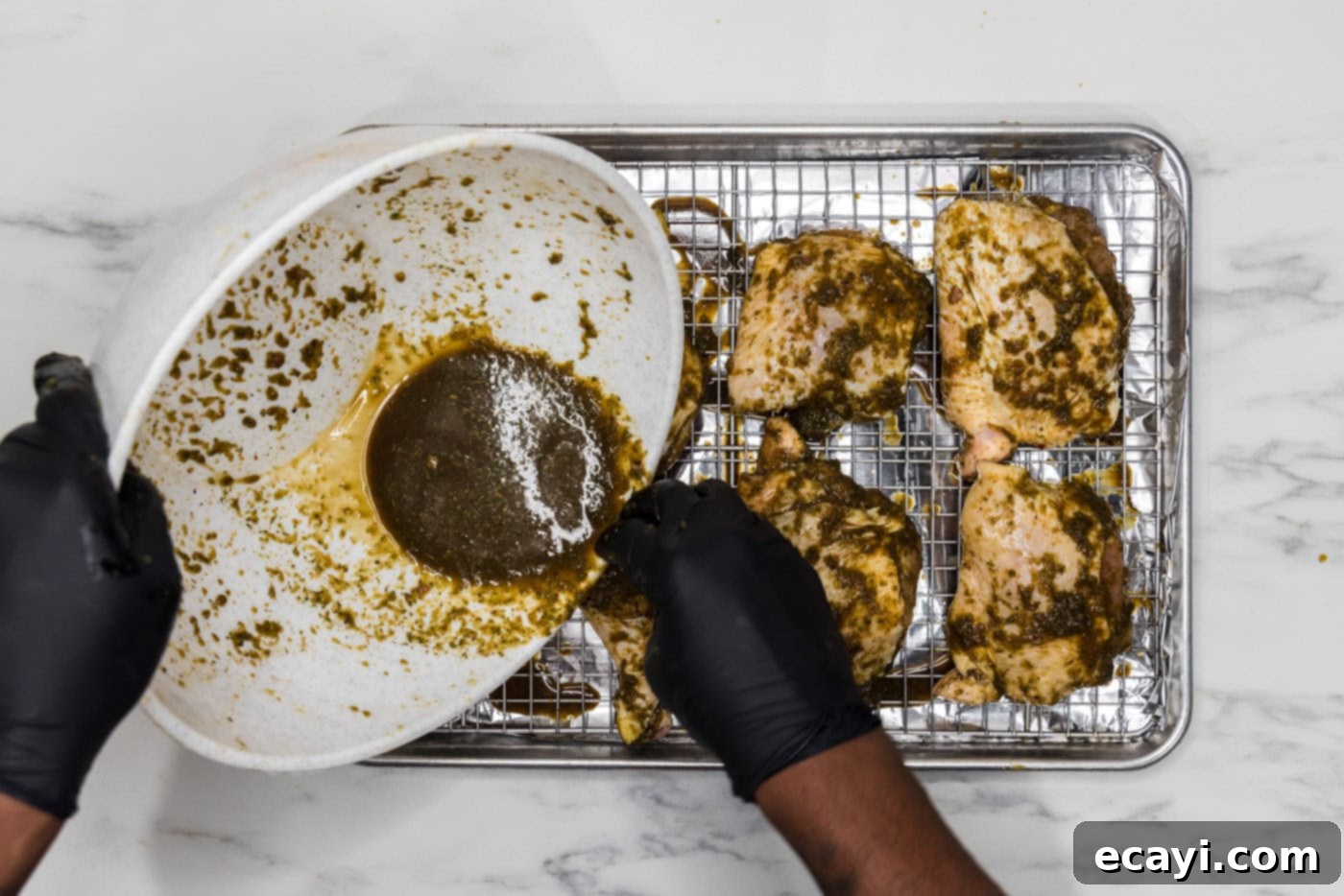 Caribbean Jerk Chicken 7 pouring extra marinade over chicken on a wire rack