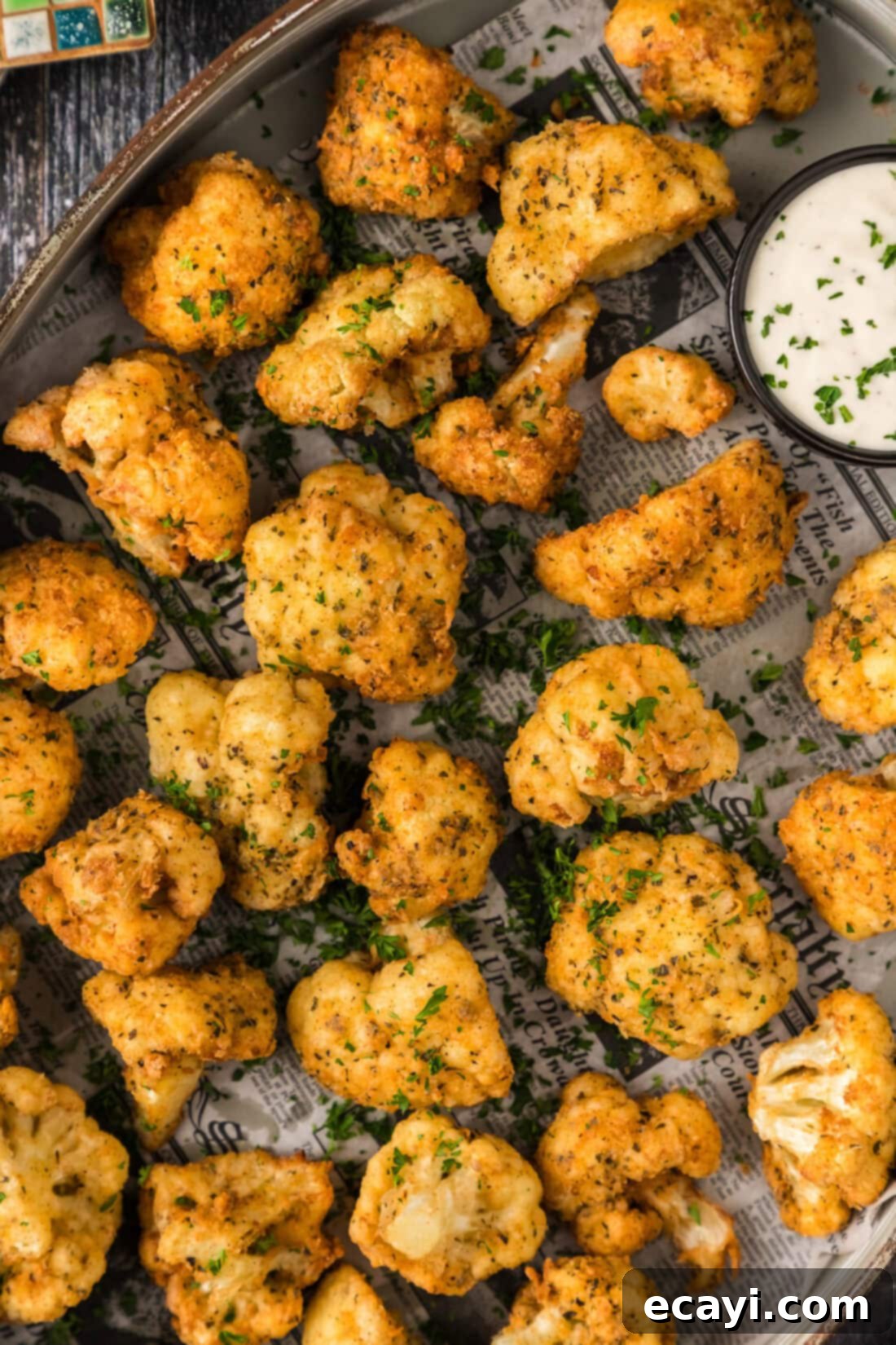 Golden Fried Florets 12 Close up overhead photo of a platter of golden Fried Cauliflower, garnished with fresh herbs, ready to be served