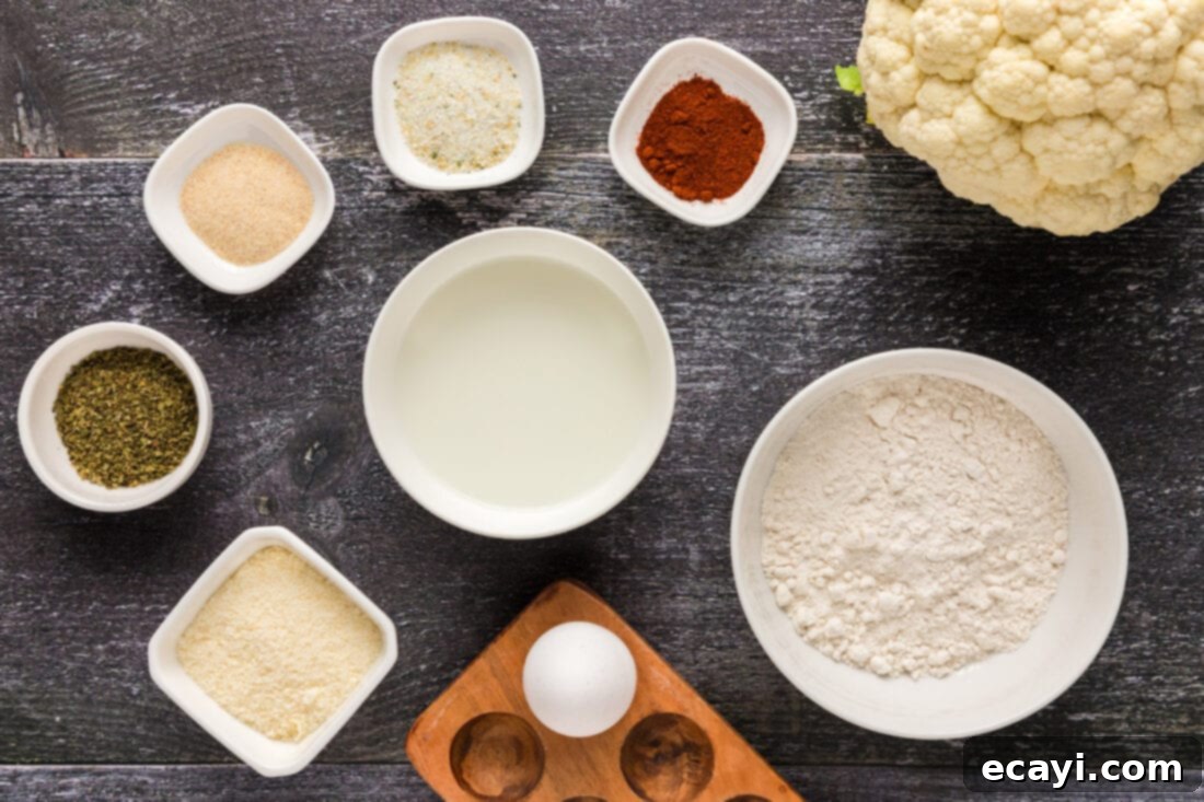 Golden Fried Florets 4 A flat lay photograph displaying all the ingredients for Fried Cauliflower, including fresh cauliflower, eggs, milk, flour, and various spices.