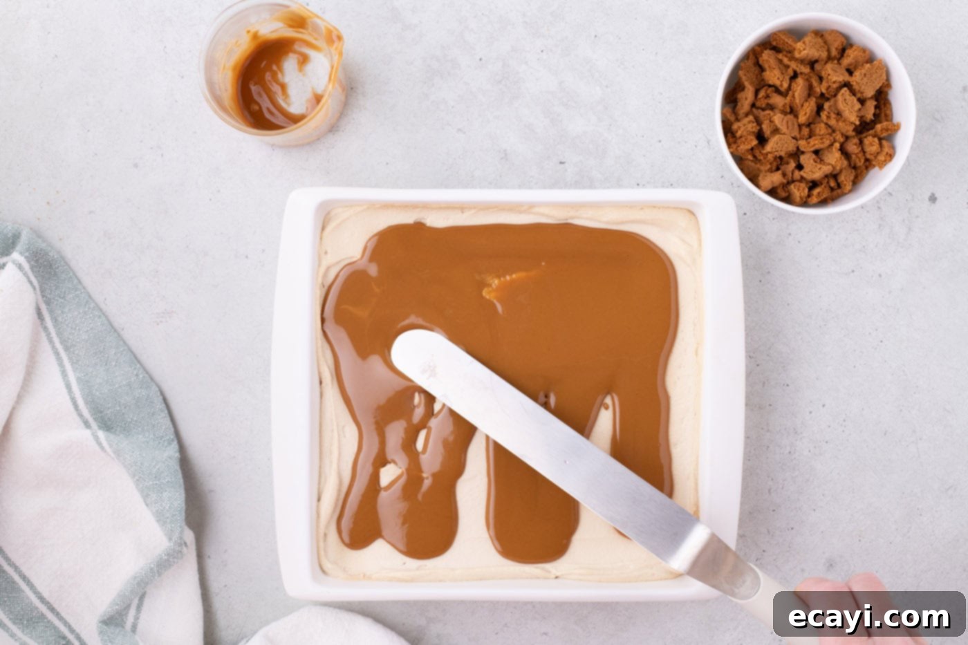 No-Bake Biscoff Bliss 13 spreading cookie butter over Biscoff icebox cake