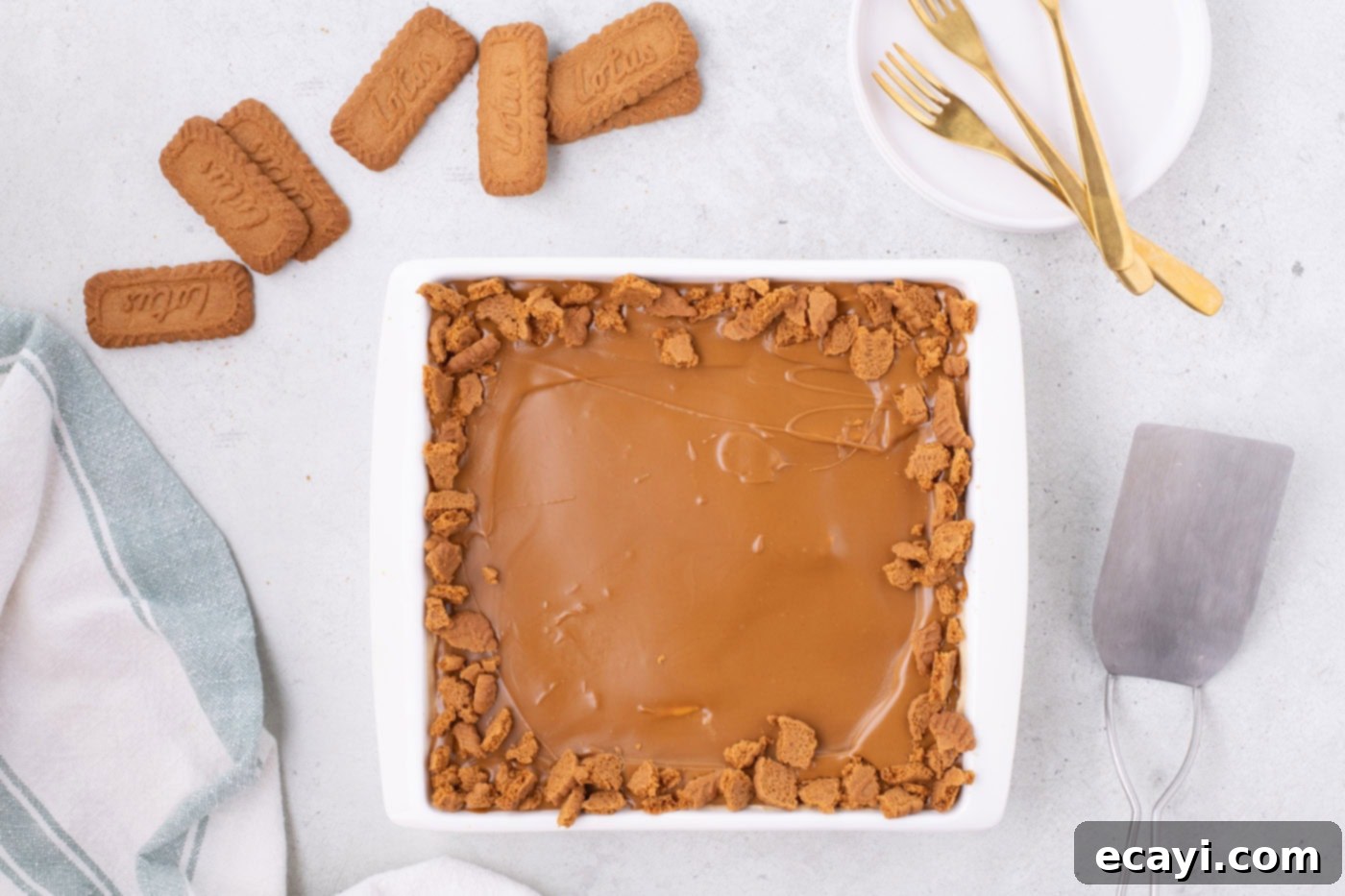 No-Bake Biscoff Bliss 14 Biscoff icebox cake in a baking dish with cookie butter and crushed cookies as garnish