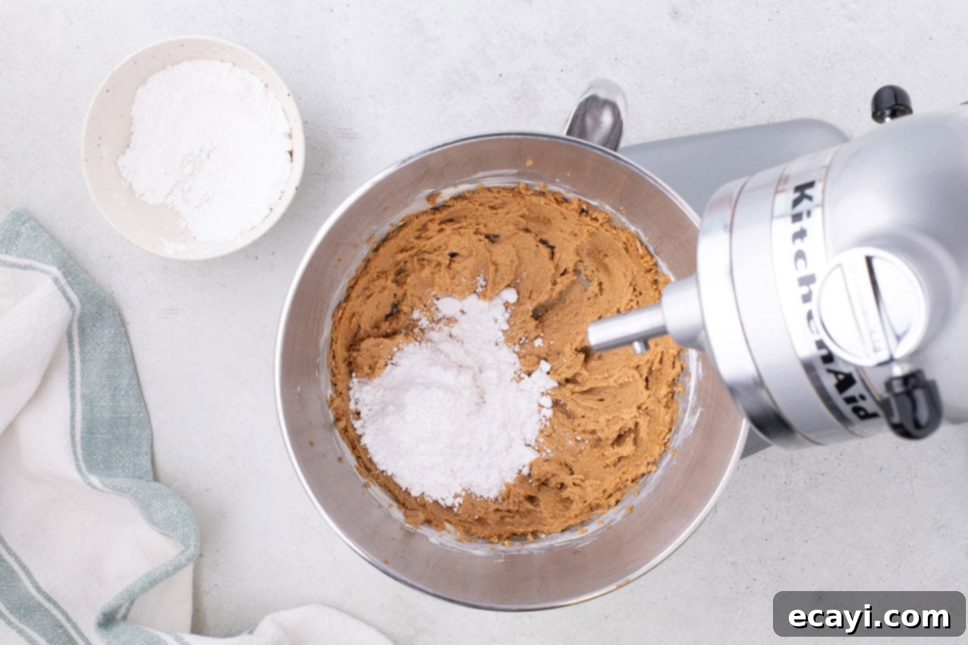 No-Bake Biscoff Bliss 6 combining powdered sugar with cookie butter and cream cheese mixture in a mixer bowl