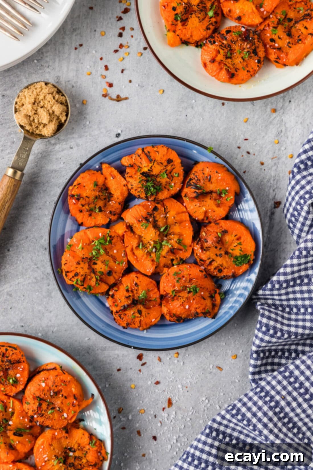 Golden Carrot Crush 2 Smashed Carrots on a blue plate, garnished with fresh herbs