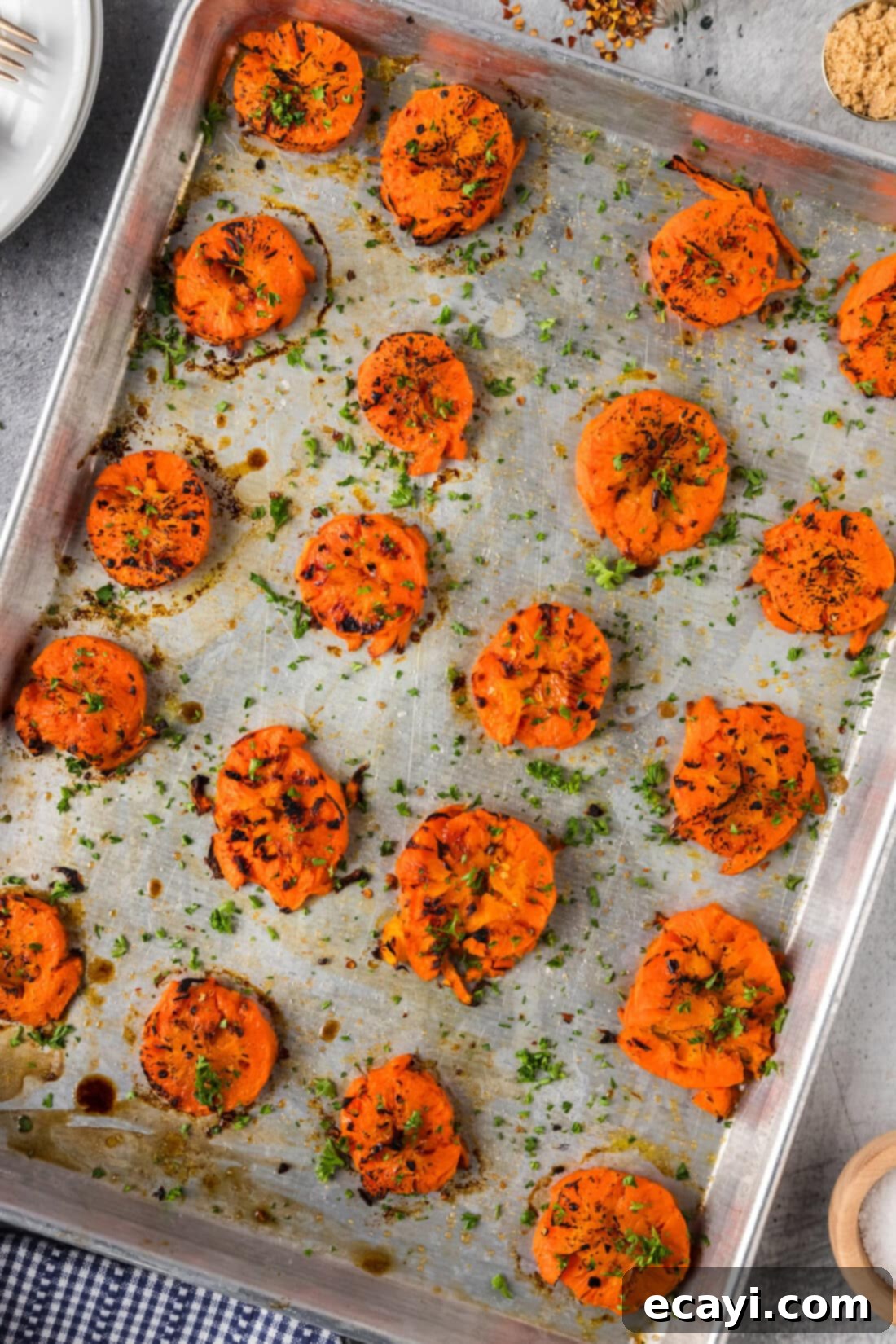Golden Carrot Crush 11 Smashed Carrots on a baking sheet after being baked to golden perfection