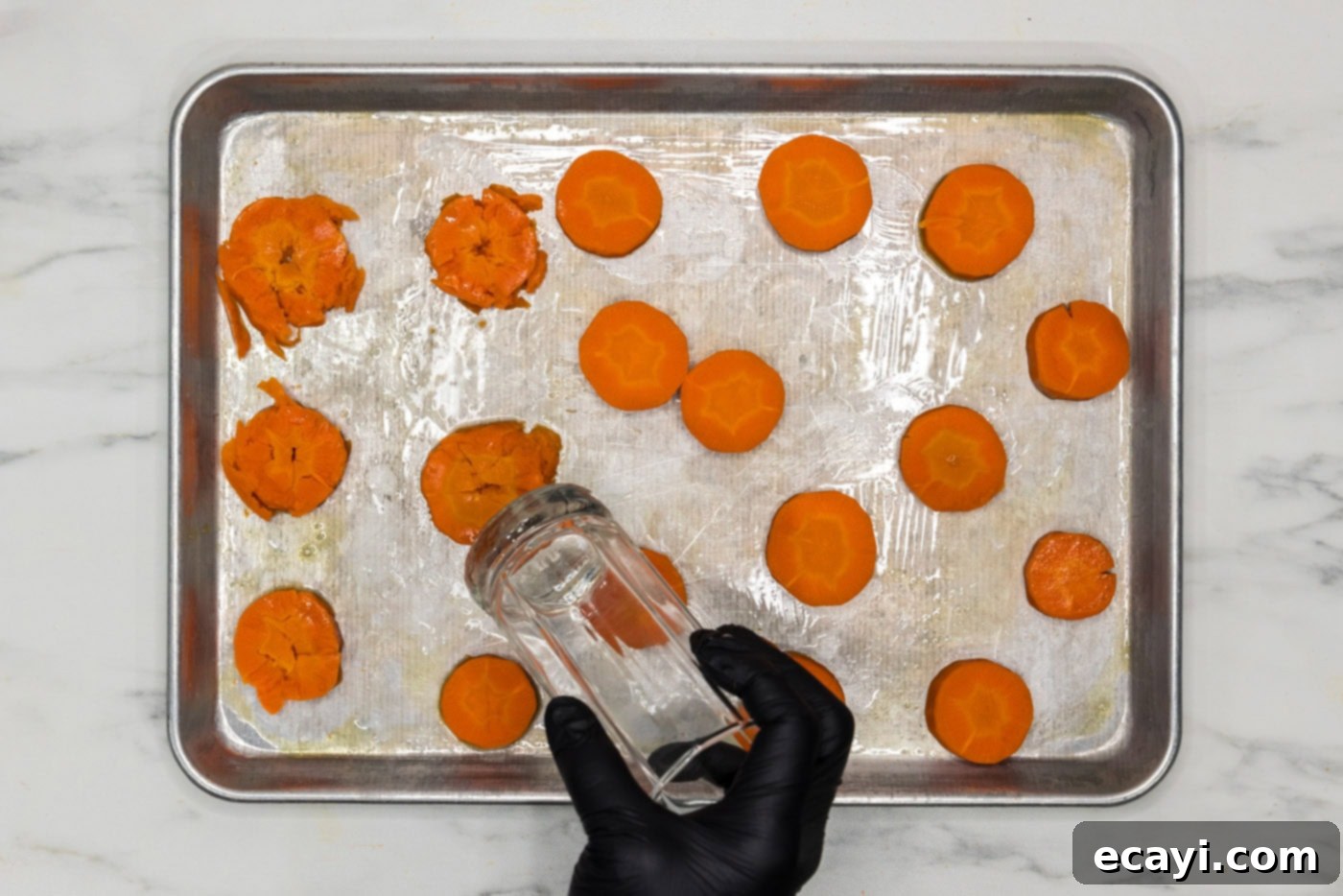 Golden Carrot Crush 8 smashed carrots on a baking sheet with the flat end of a drinking glass