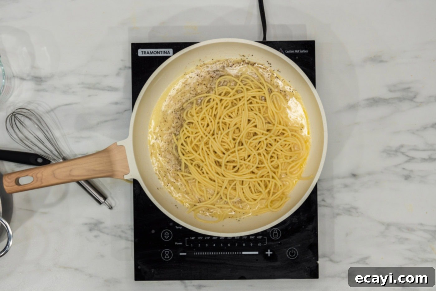 Irresistible Garlic Butter Pasta 6 Cooked spaghetti noodles being added to a large skillet with the simmering garlic butter sauce, ready to be tossed and coated.