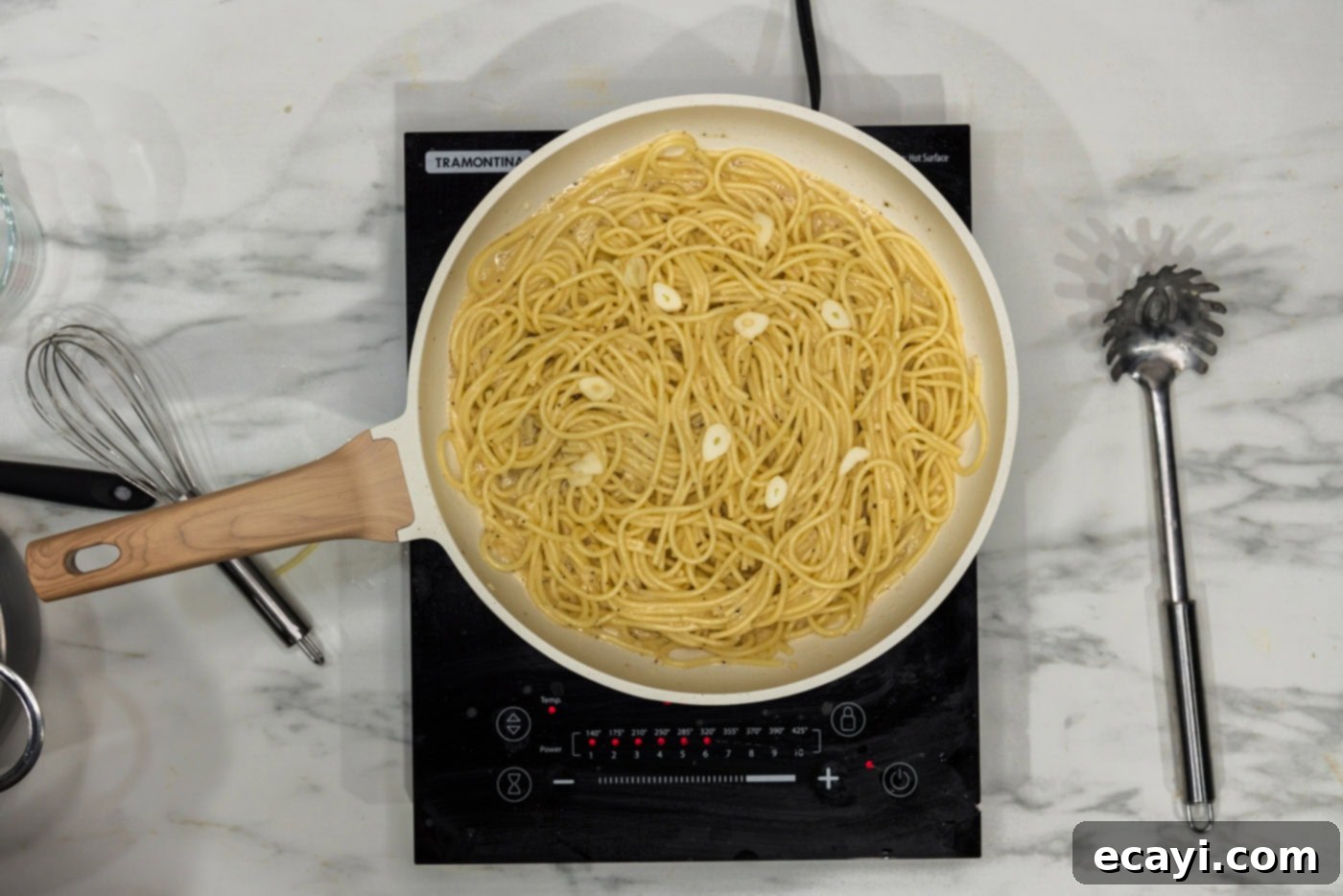 Irresistible Garlic Butter Pasta 7 Slivered fresh garlic being stirred into the garlic butter pasta within the skillet, adding a final touch of vibrant flavor.