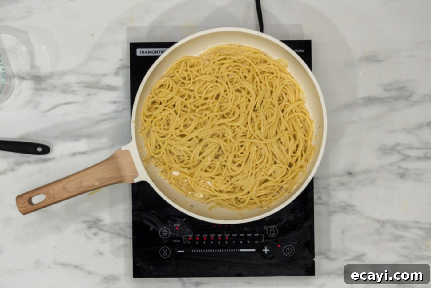 Irresistible Garlic Butter Pasta 8 The finished garlic butter pasta resting in a skillet on a stovetop burner, looking perfectly saucy and ready to serve.