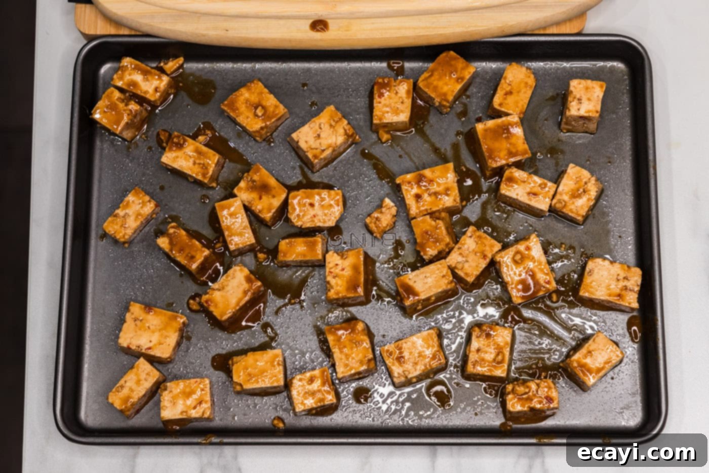 Fiery Tofu 9 sauced tofu cubes arranged on a baking sheet before baking