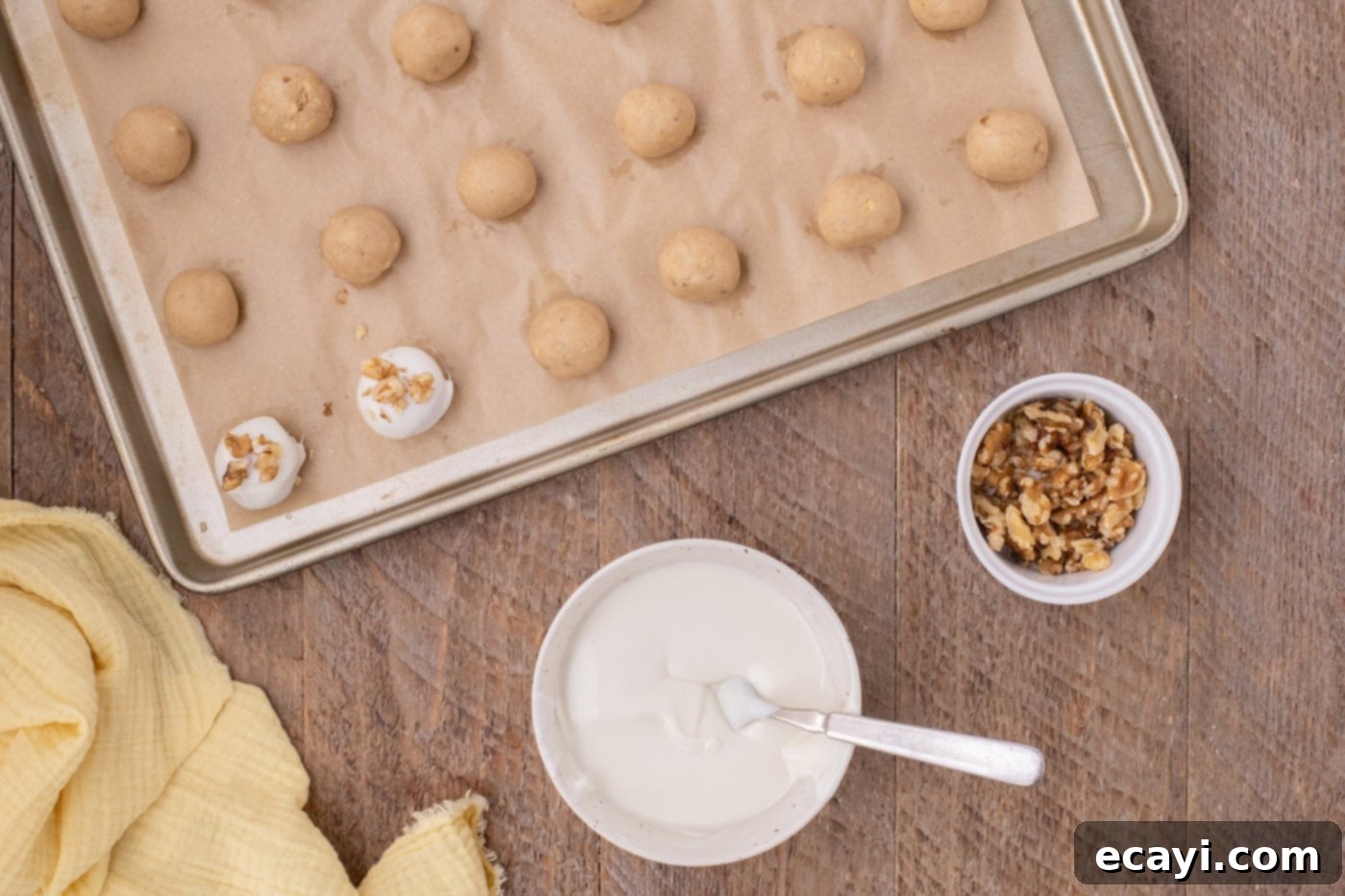 Banana Bliss Truffles 12 white chocolate coated banana truffles with walnuts on a baking sheet