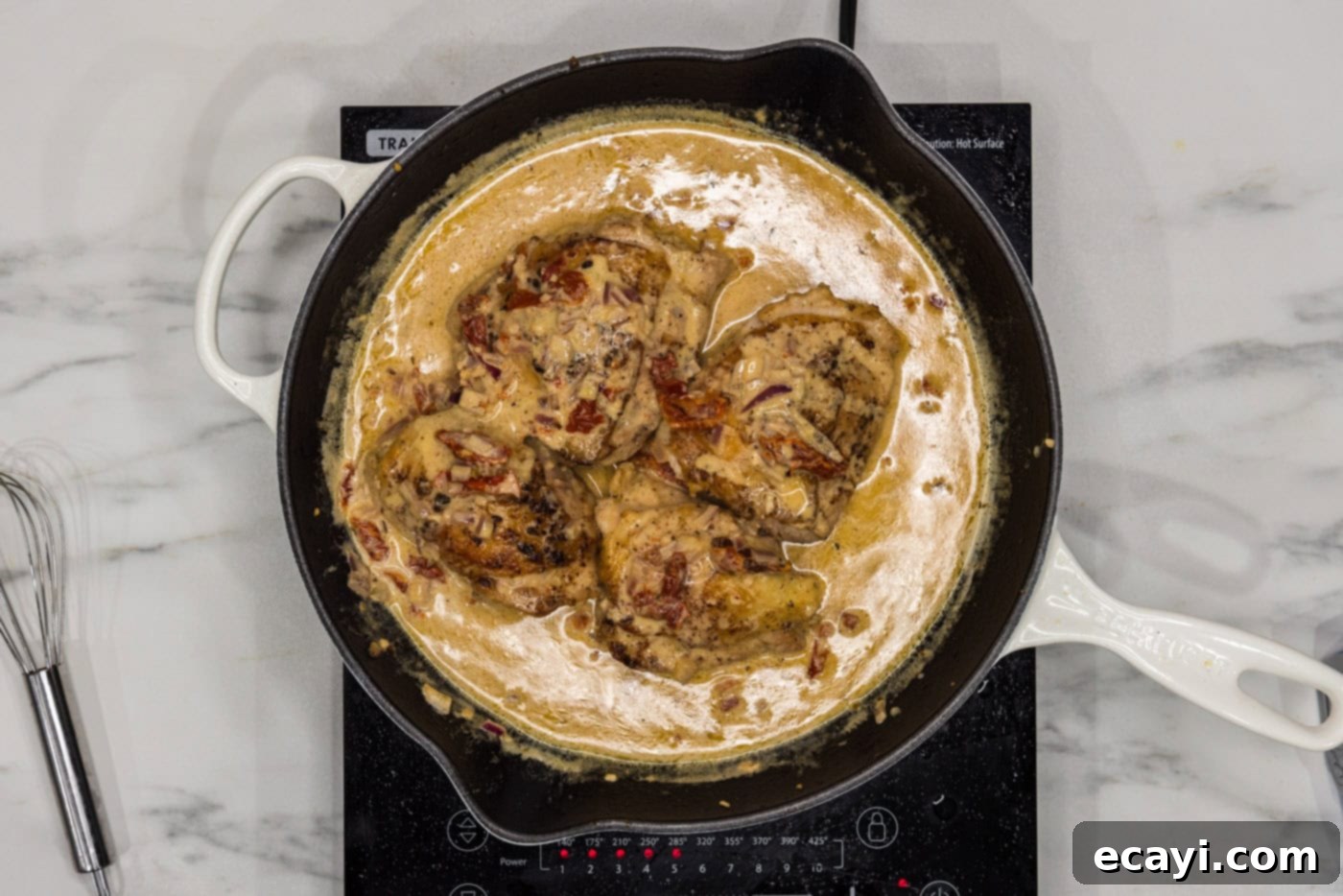 Crispy Skillet Chicken Thighs 12 chicken thighs in a skillet with sun dried tomatoes and cream sauce