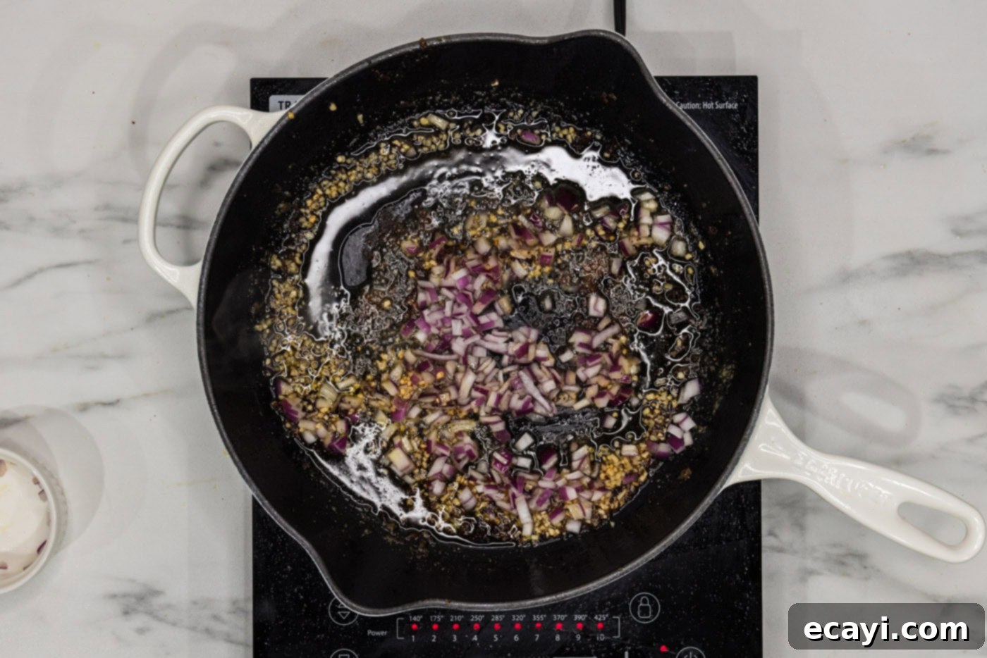 Crispy Skillet Chicken Thighs 8 garlic and red onion in a skillet