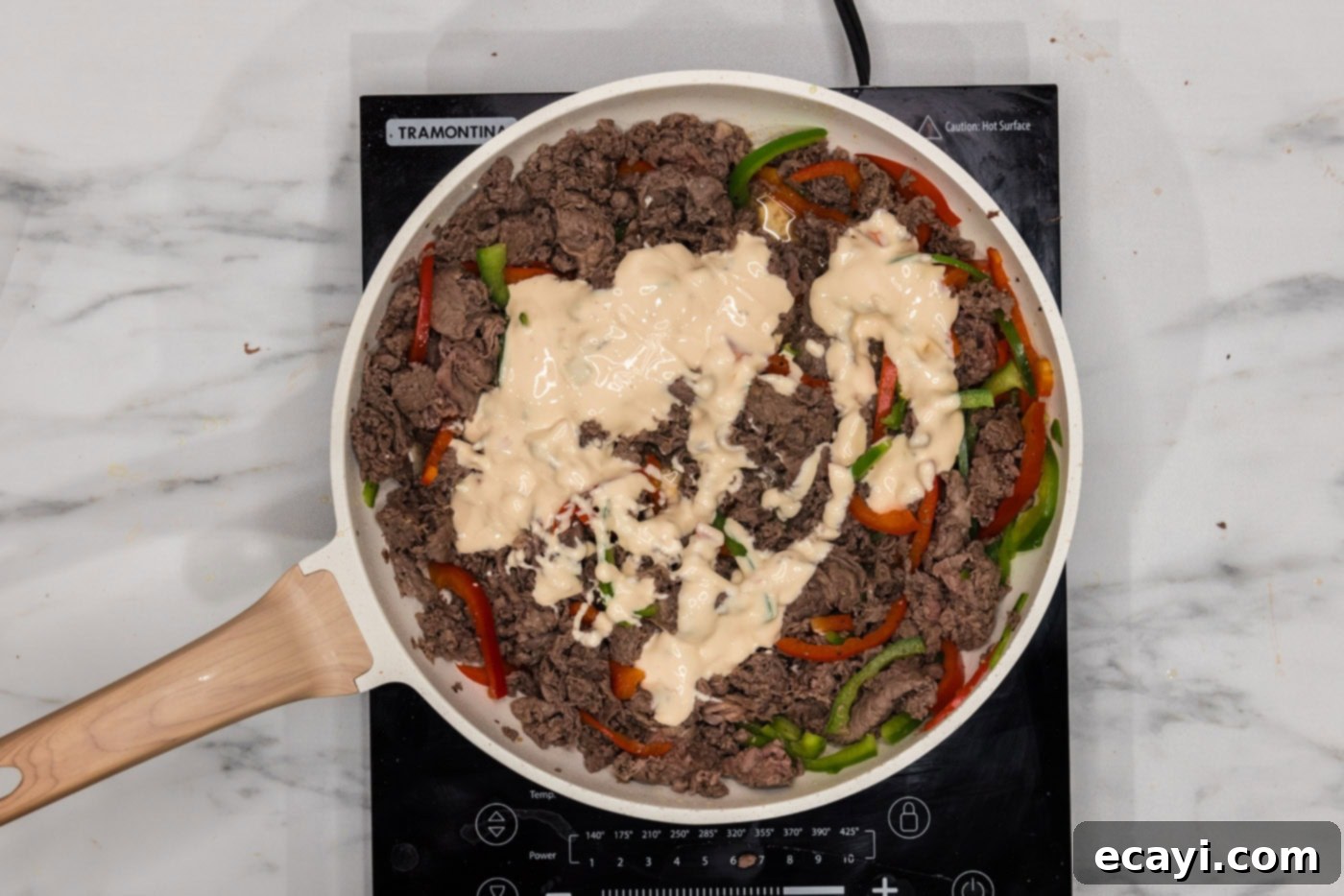 Cheesesteak Slider Bites 7 queso blanco added to skillet with bell peppers and beef