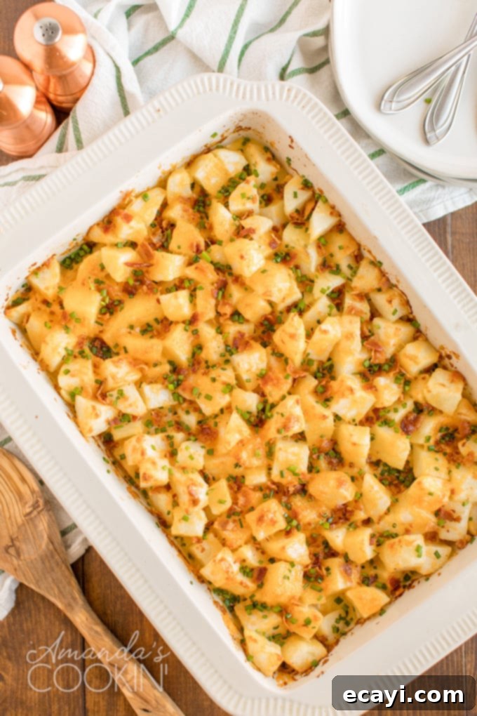 Cheddar, Monterey jack and smoked mozzarella come together in this delicious three cheese potatoes dish. Perfect to serve a crowd or to bring to a potluck. A golden-brown pan of bubbling three cheese potatoes casserole, topped with crispy bacon bits and fresh green chives, ready to serve.
