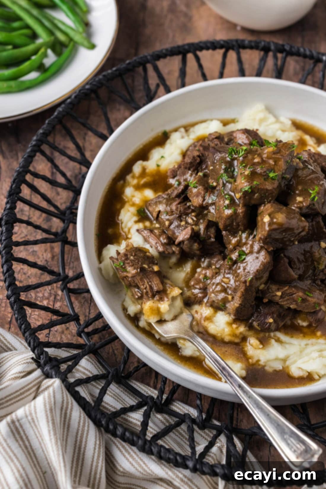 Easy Instant Pot Beef Tips and Gravy 2 Close up photo of Instant Pot Beef Tips and Gravy served over mashed potatoes with a piece on a fork