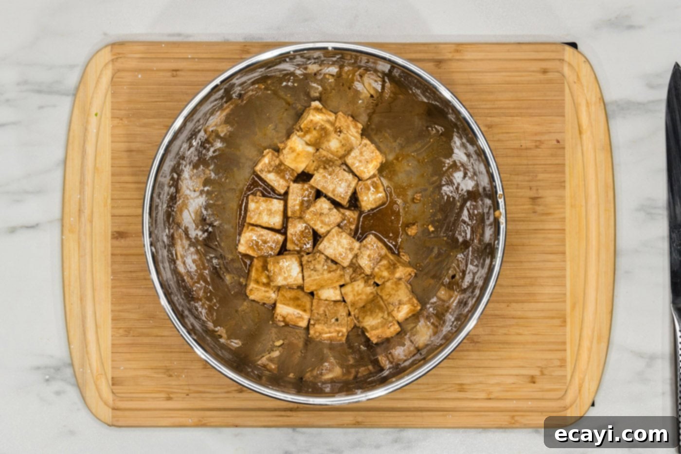 Crispy Air Fryer Tofu 8 cubed tofu in a bowl, now with soy sauce, cornstarch, and sesame oil, ready for final toss