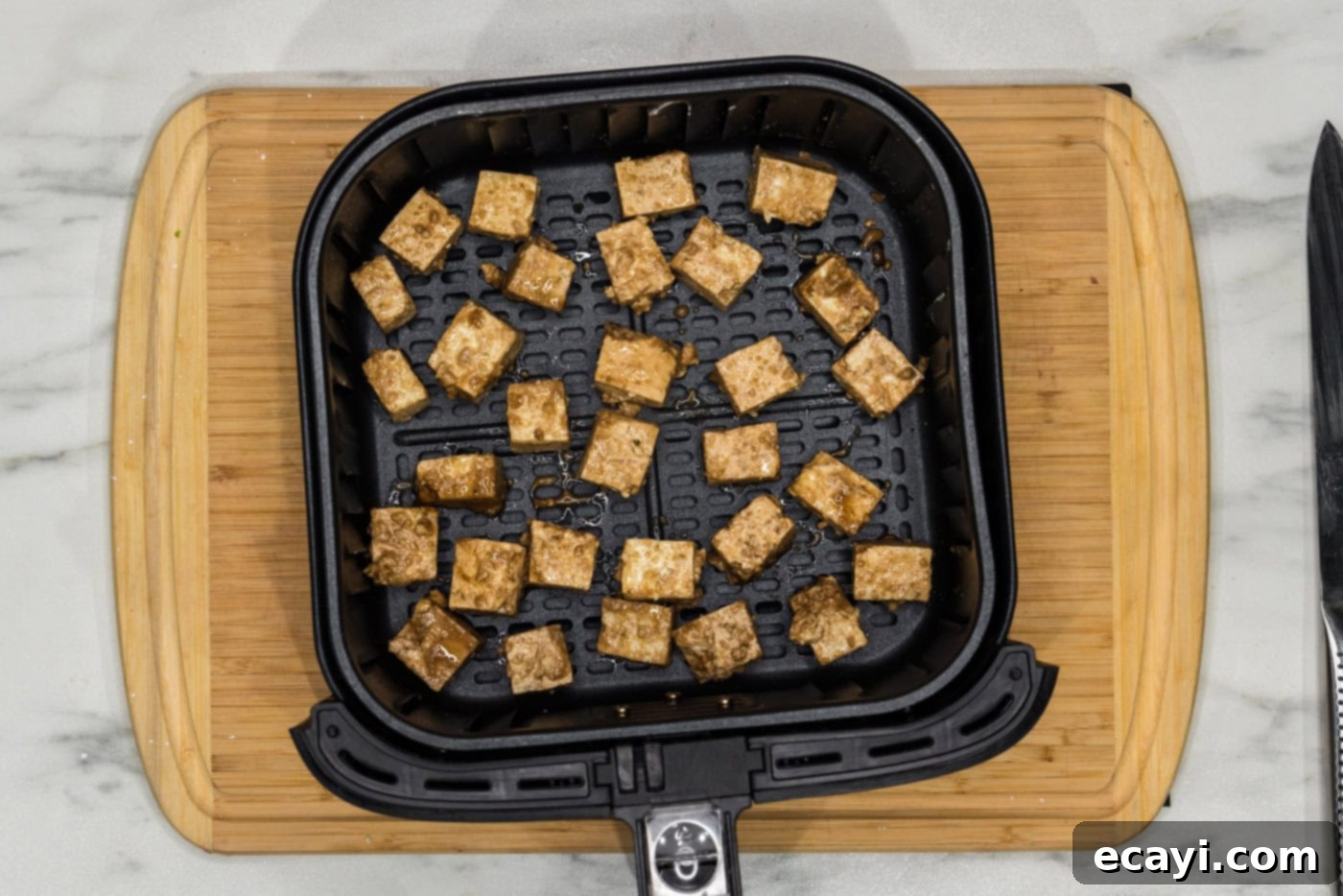 Crispy Air Fryer Tofu 9 tofu cubes arranged in a single layer in an air fryer basket
