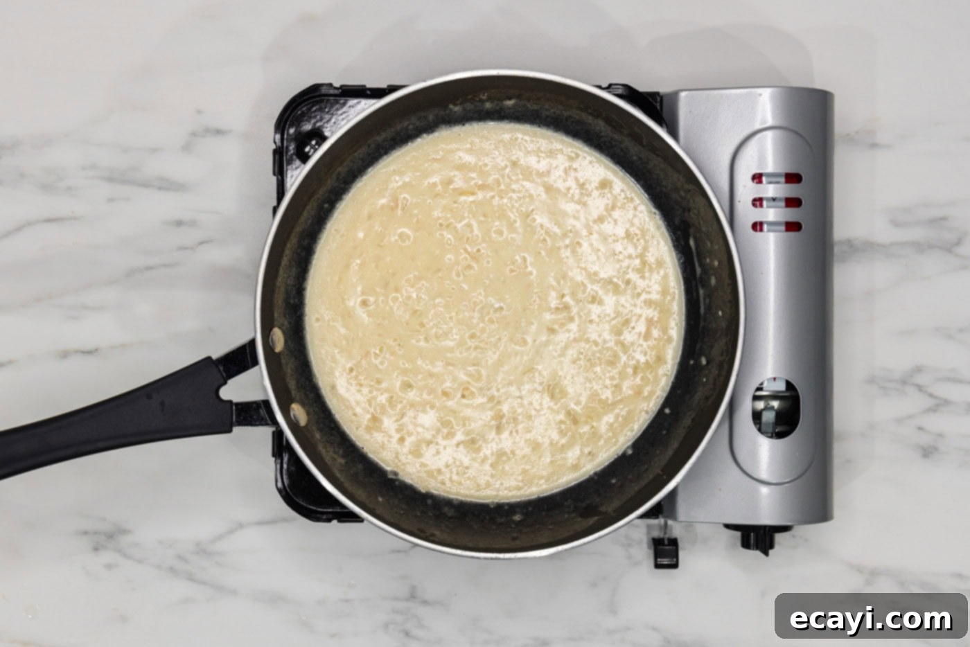 Perfectly Baked Chilean Sea Bass 11 A close-up of a beautifully smooth and easy beurre blanc sauce simmering in a skillet, ready to be served.