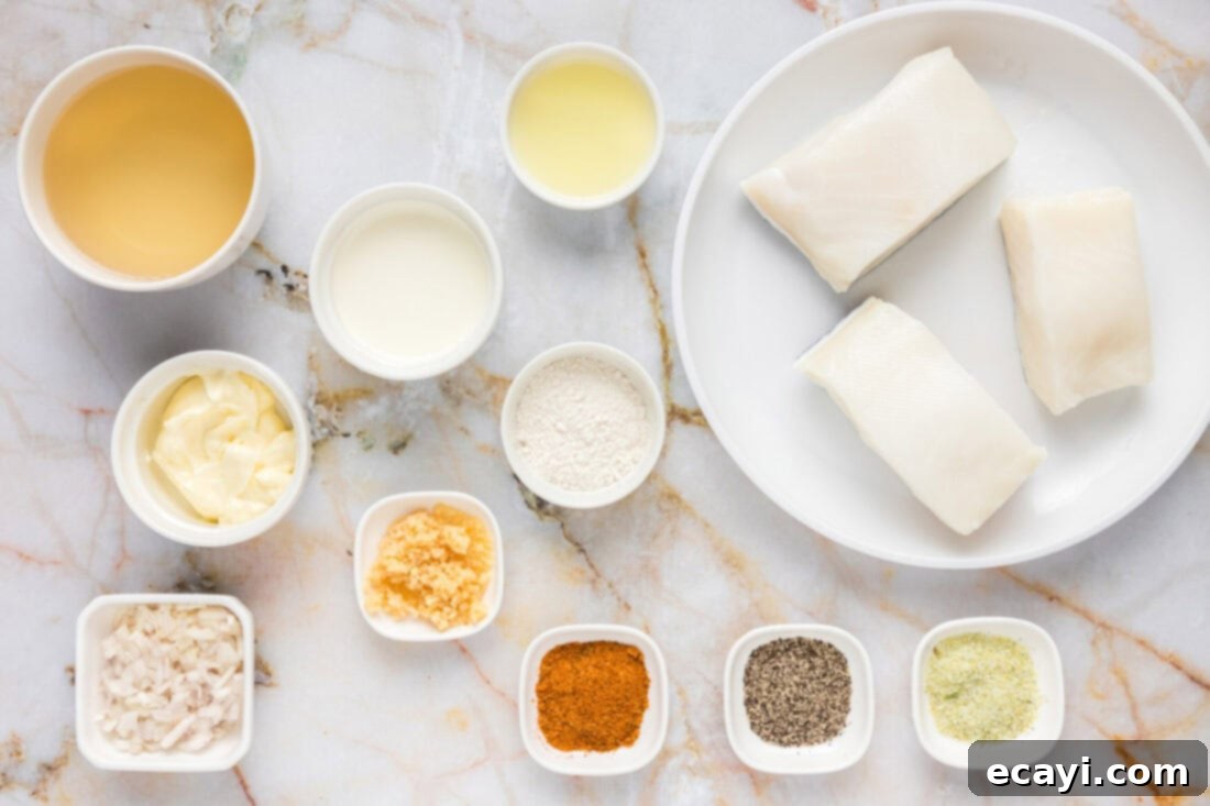 Perfectly Baked Chilean Sea Bass 4 A vibrant flat lay photo displaying all fresh ingredients laid out for preparing Baked Chilean Sea Bass and Beurre Blanc sauce, including fish fillets, butter, lemons, garlic, shallots, and herbs.