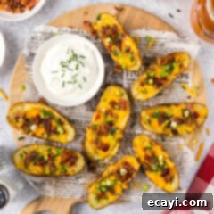 Loaded Potato Boats 12 Potato Skins on a parchment lined wooden platter with a bowl of sour cream