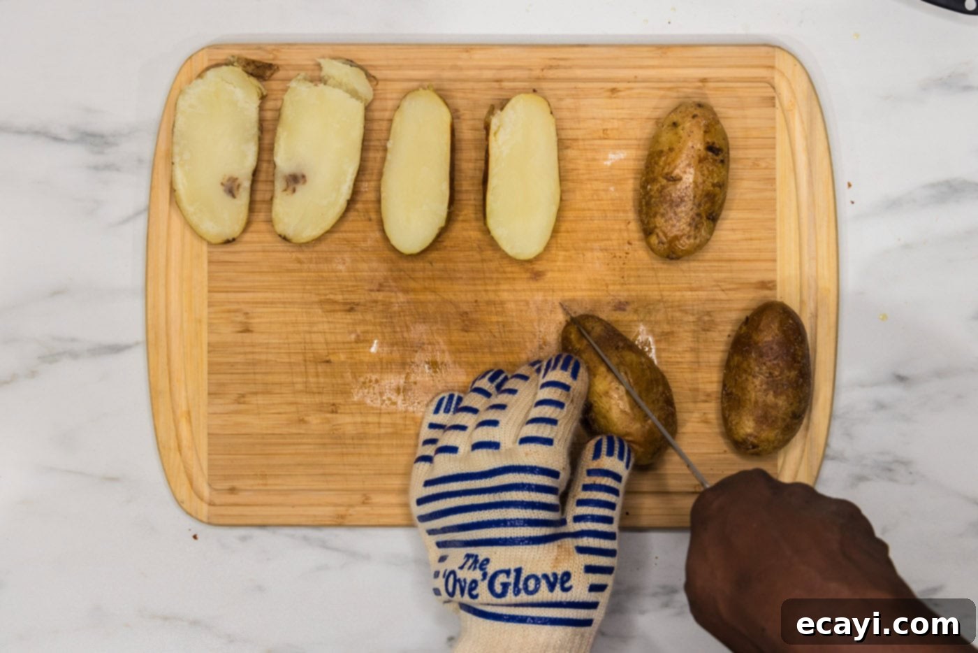 Loaded Potato Boats 7 slicing potato in half lengthwise on a cutting board